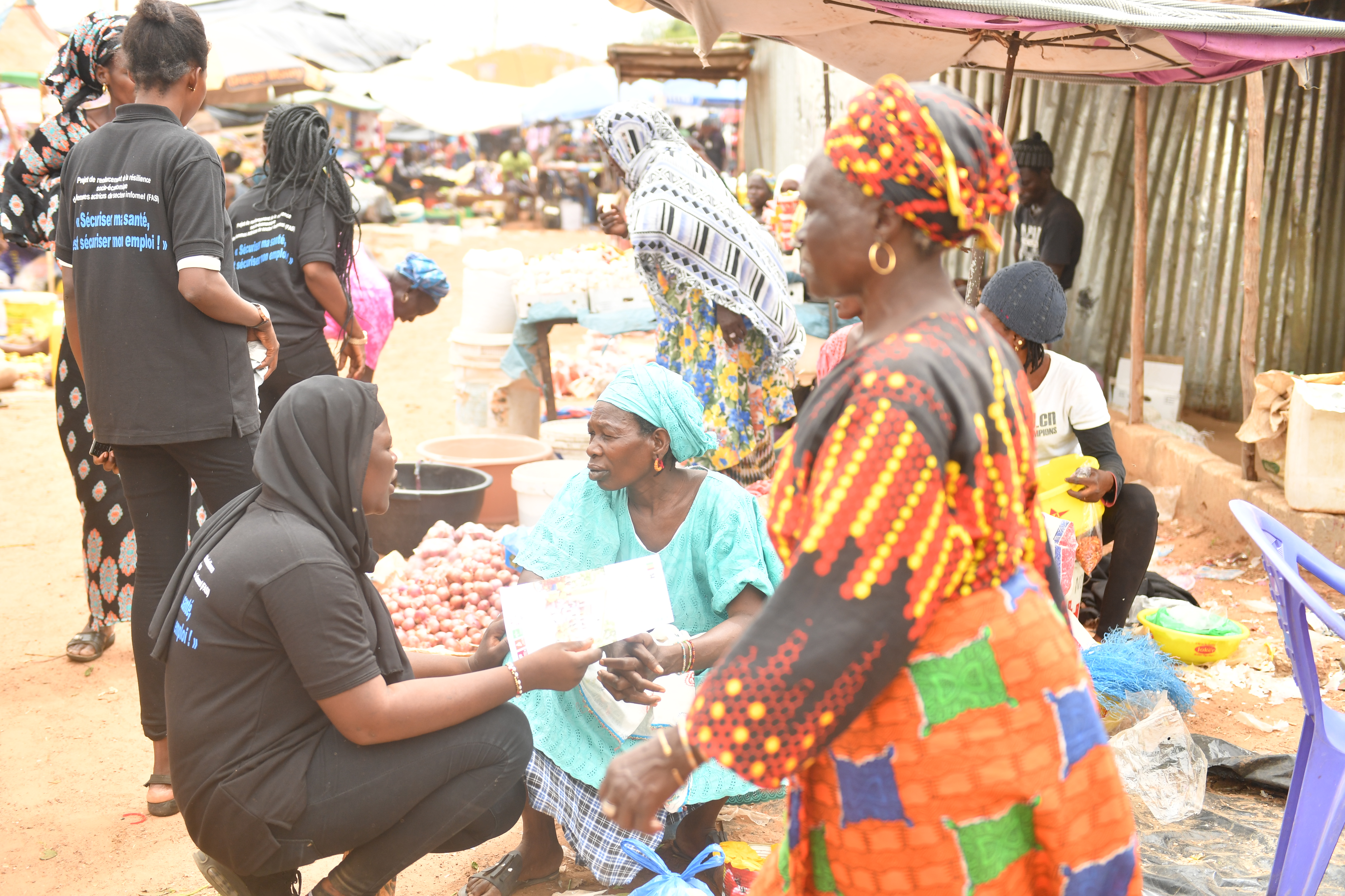 Jeune fille parlant avec des femmes vendeuses au marché