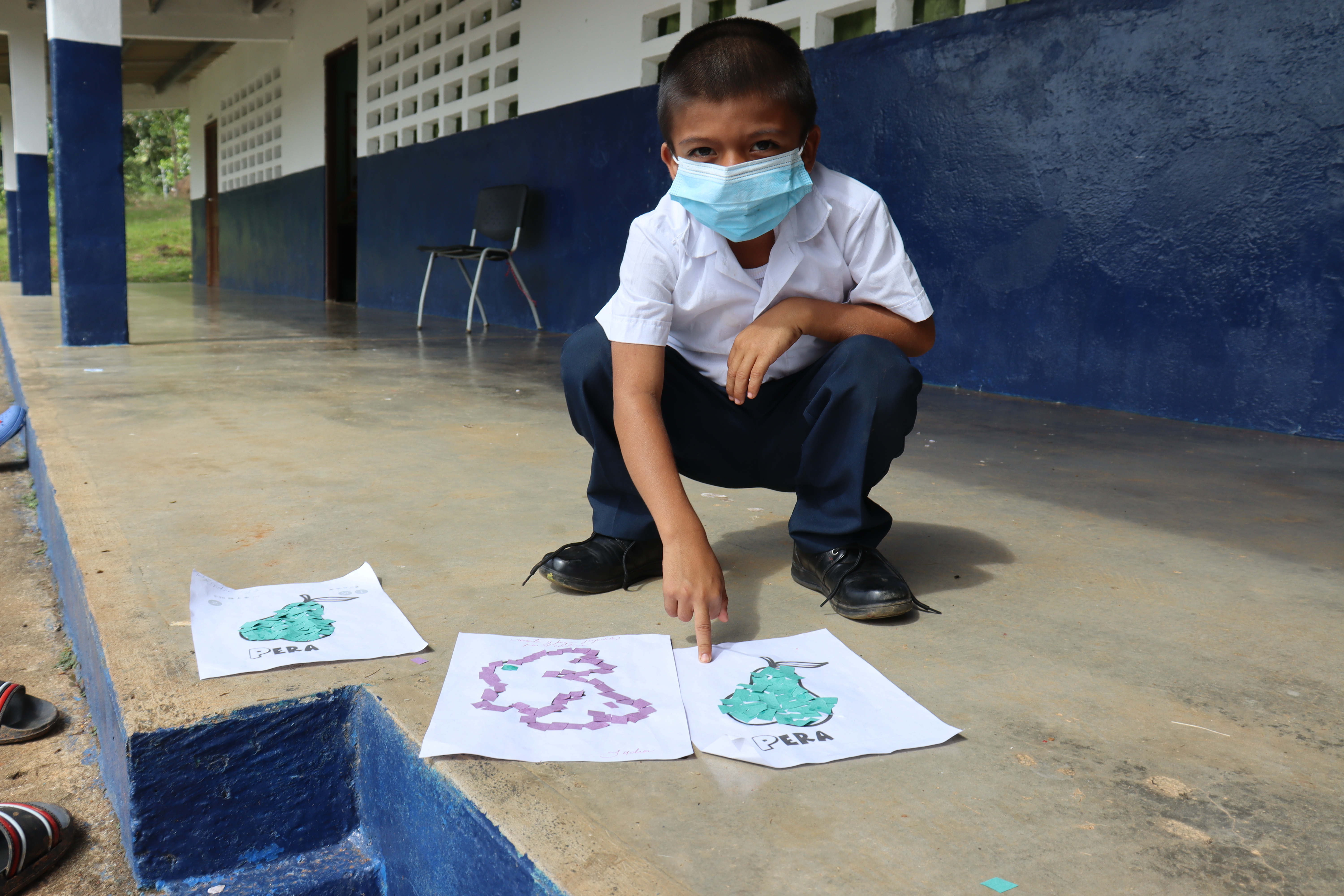 Un niño muestra su tarea en la escuela de Dos Aguas
