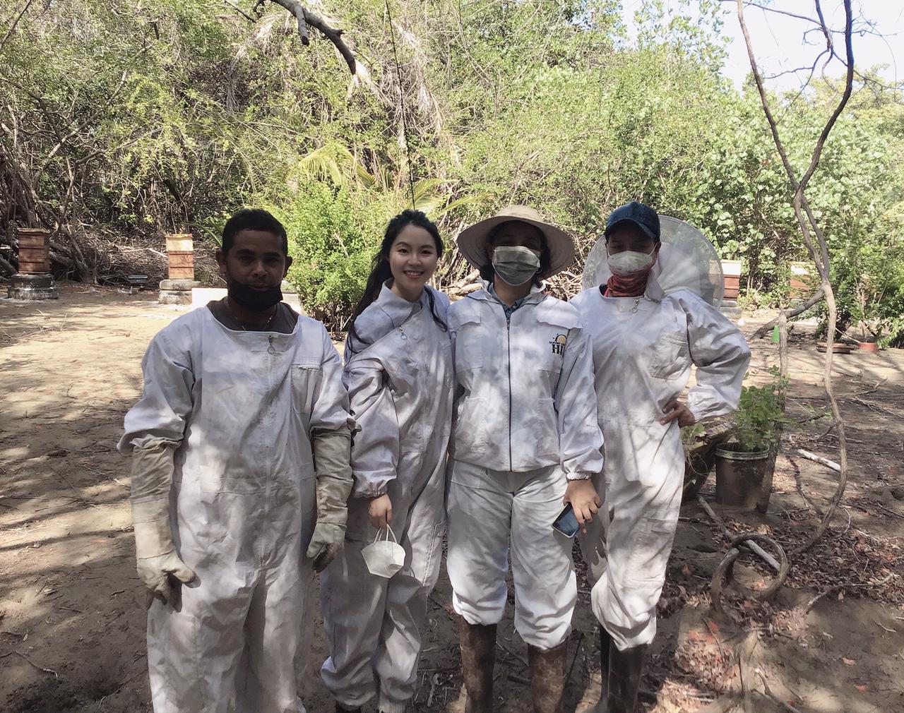 Un grupo de jovenes vestidos con elementos de protección para el cultivo de miel