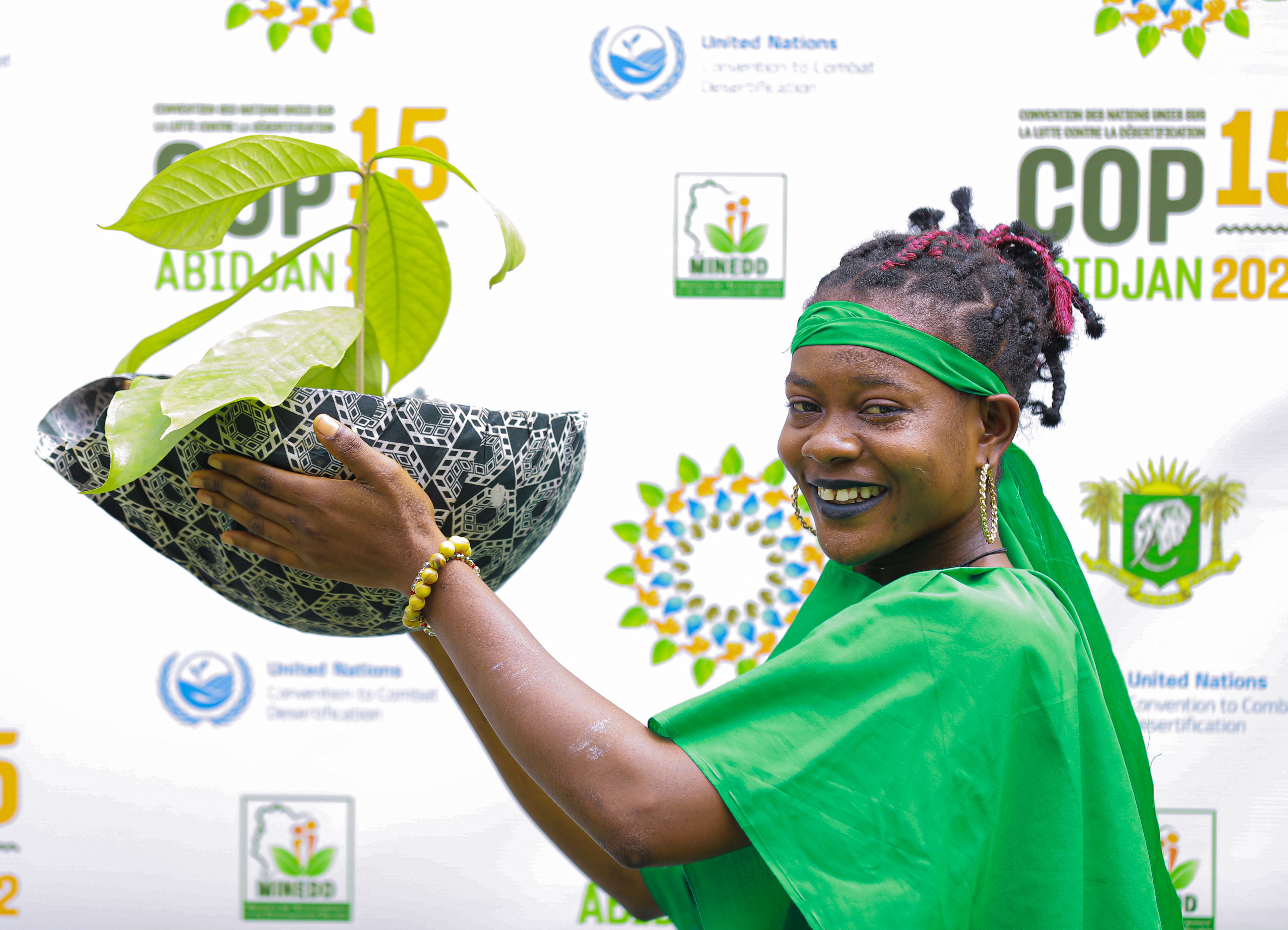 Jeune femme tenant un pot de fleur à l'occasion du lancement de la COP15