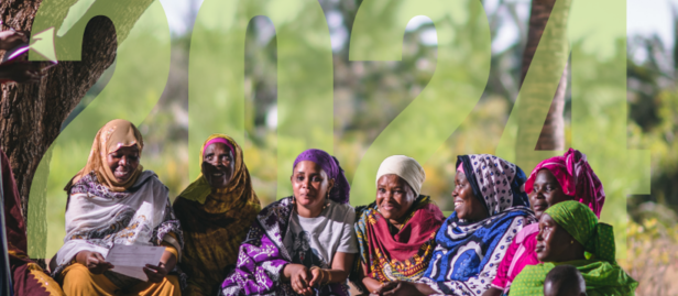 Diverse group sitting on grass under trees in an outdoor setting; 'Annual Report' with program logos.