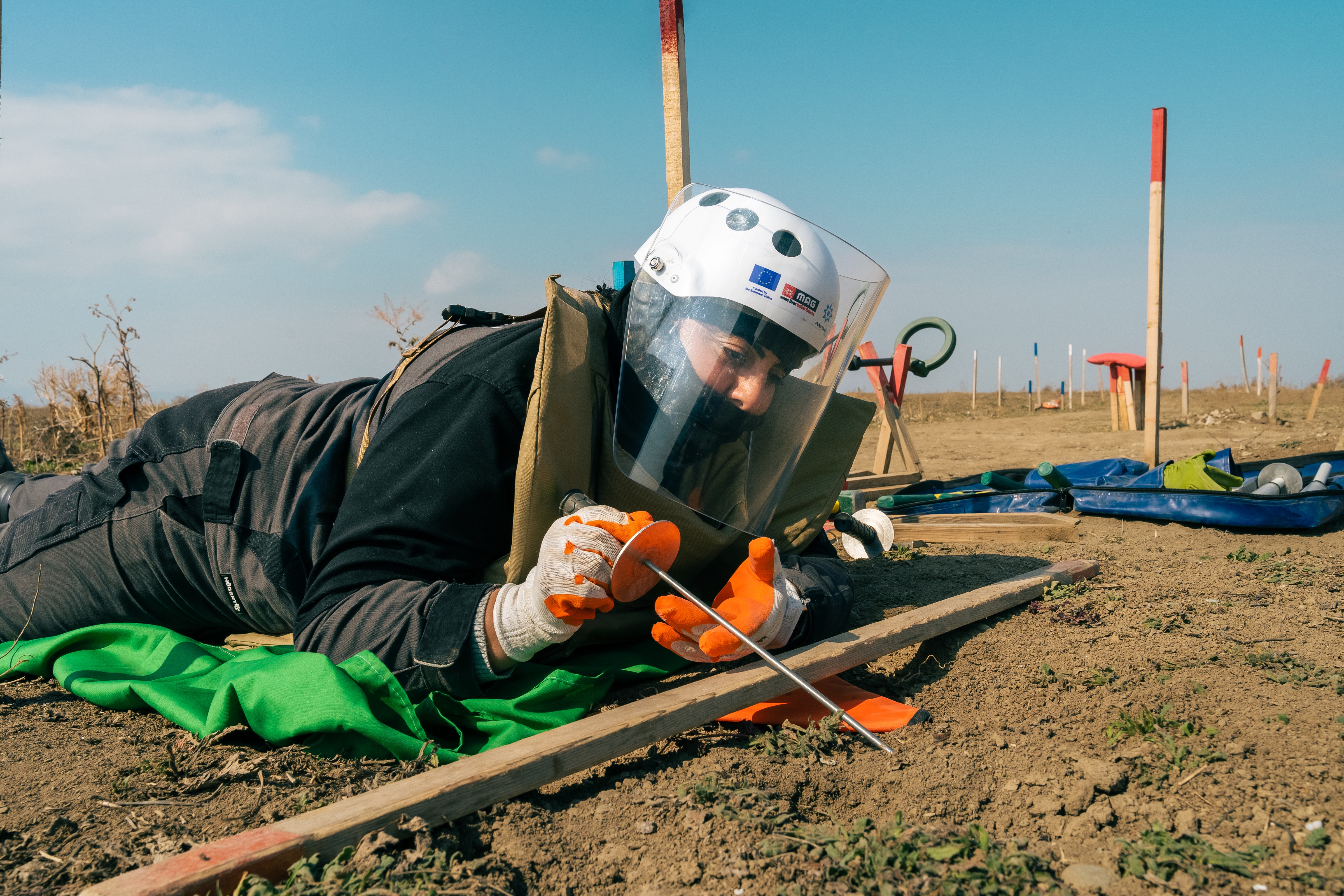 Woman extracting landmine from the ground