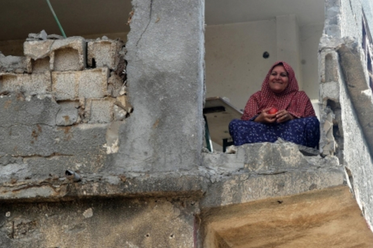 Women sitting in destroyed house