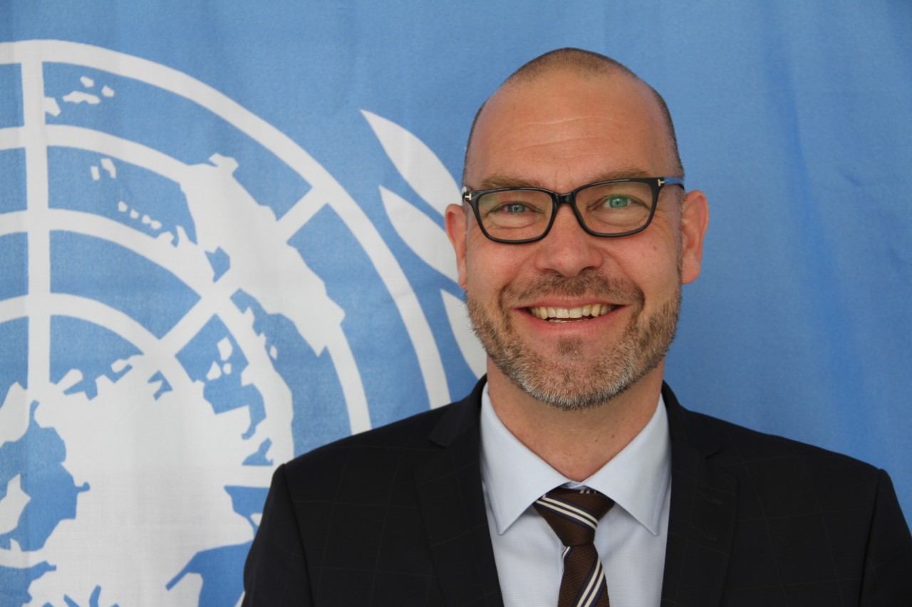Portrætfoto af en smilende Henrik Fredborg Larsen, direktør for UNDP's nordiske kontor.
