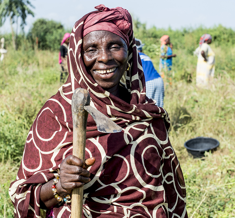 Sénégal, Commune de Ndiob - Femme avec son outil de travail au milieu d'un champ communautaire