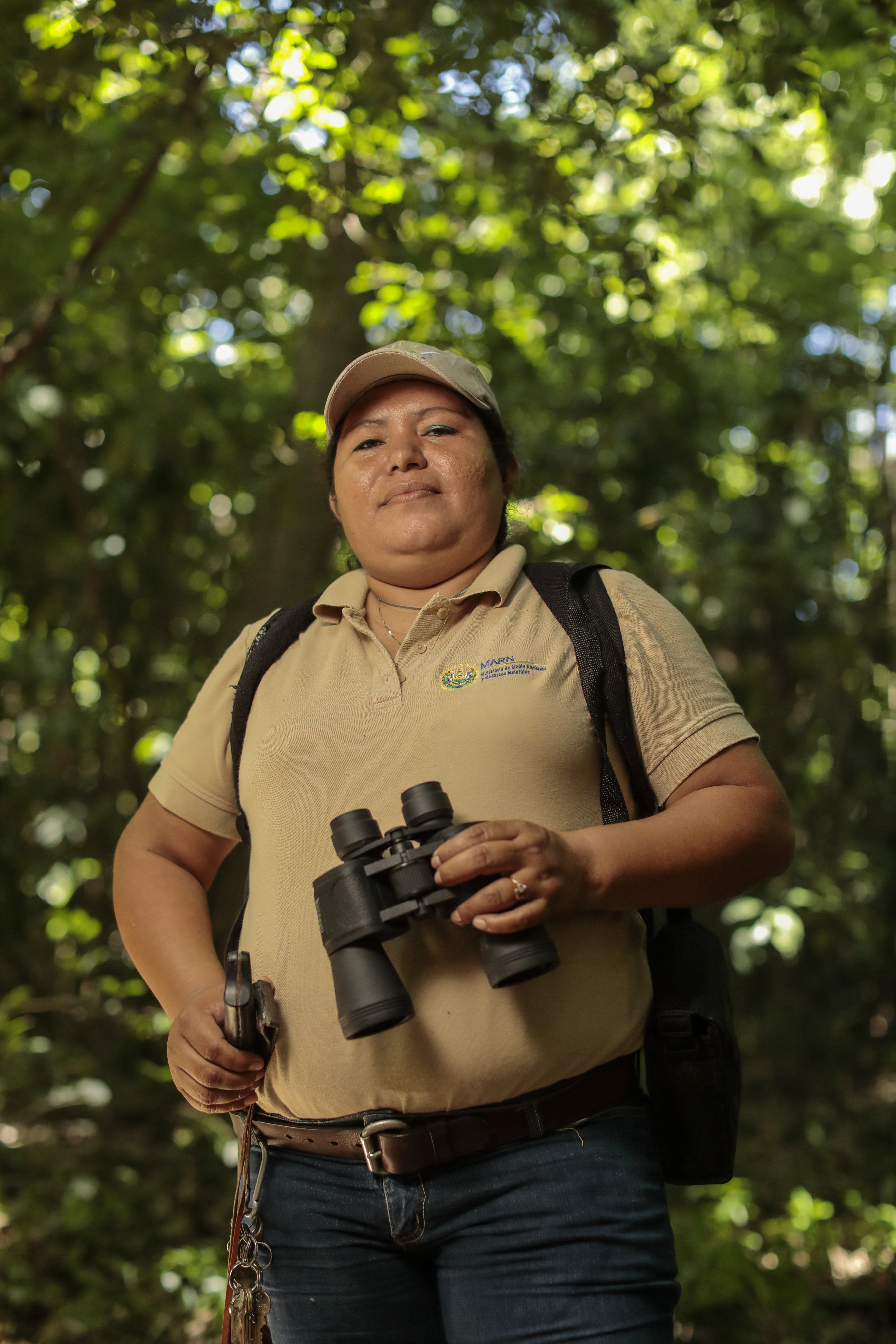 Mujer guardabosques con vinoculares en la mano