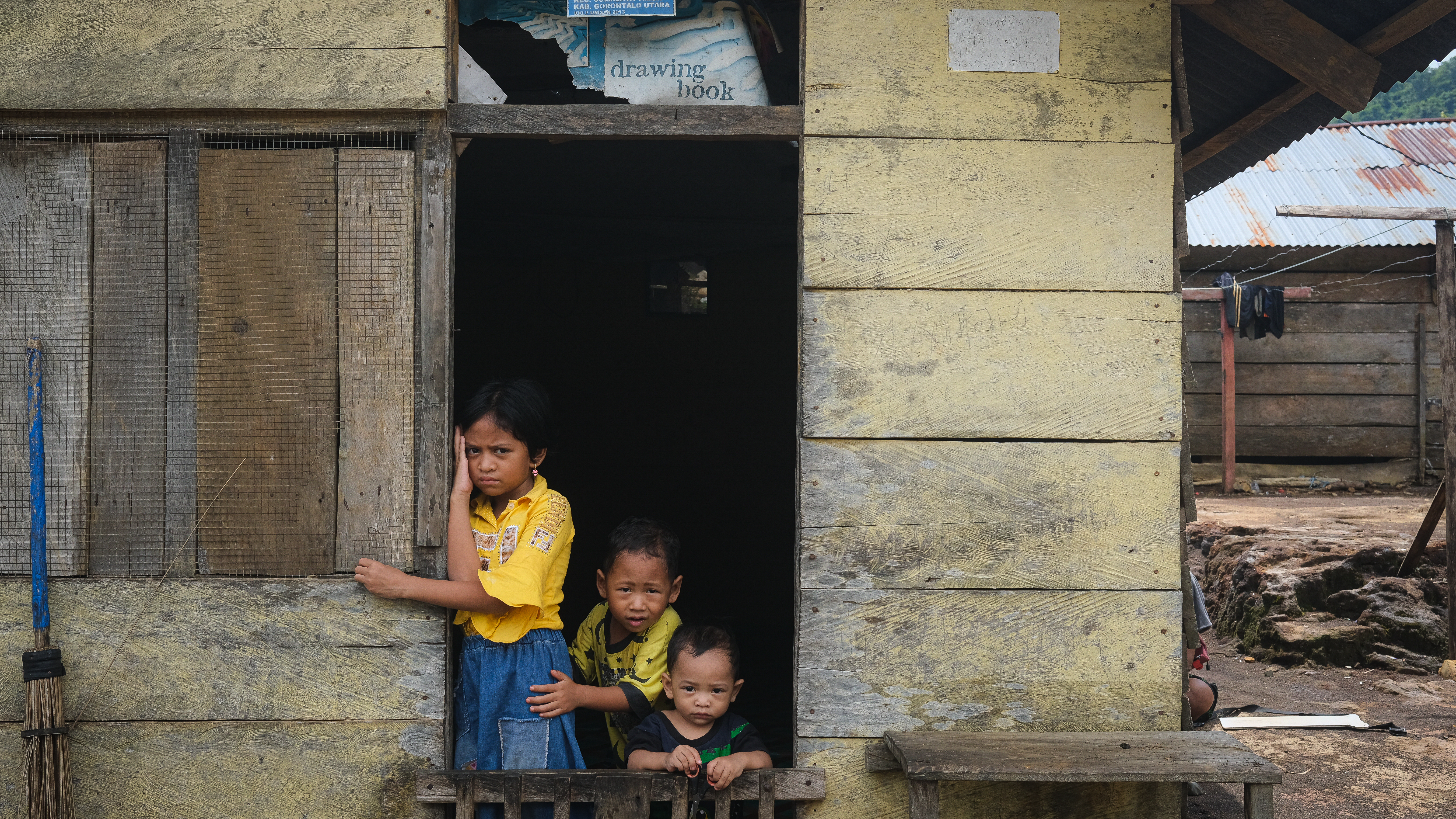 Peek-a-boo; children peeking from their houses just a few meters away from the gold extraction place.