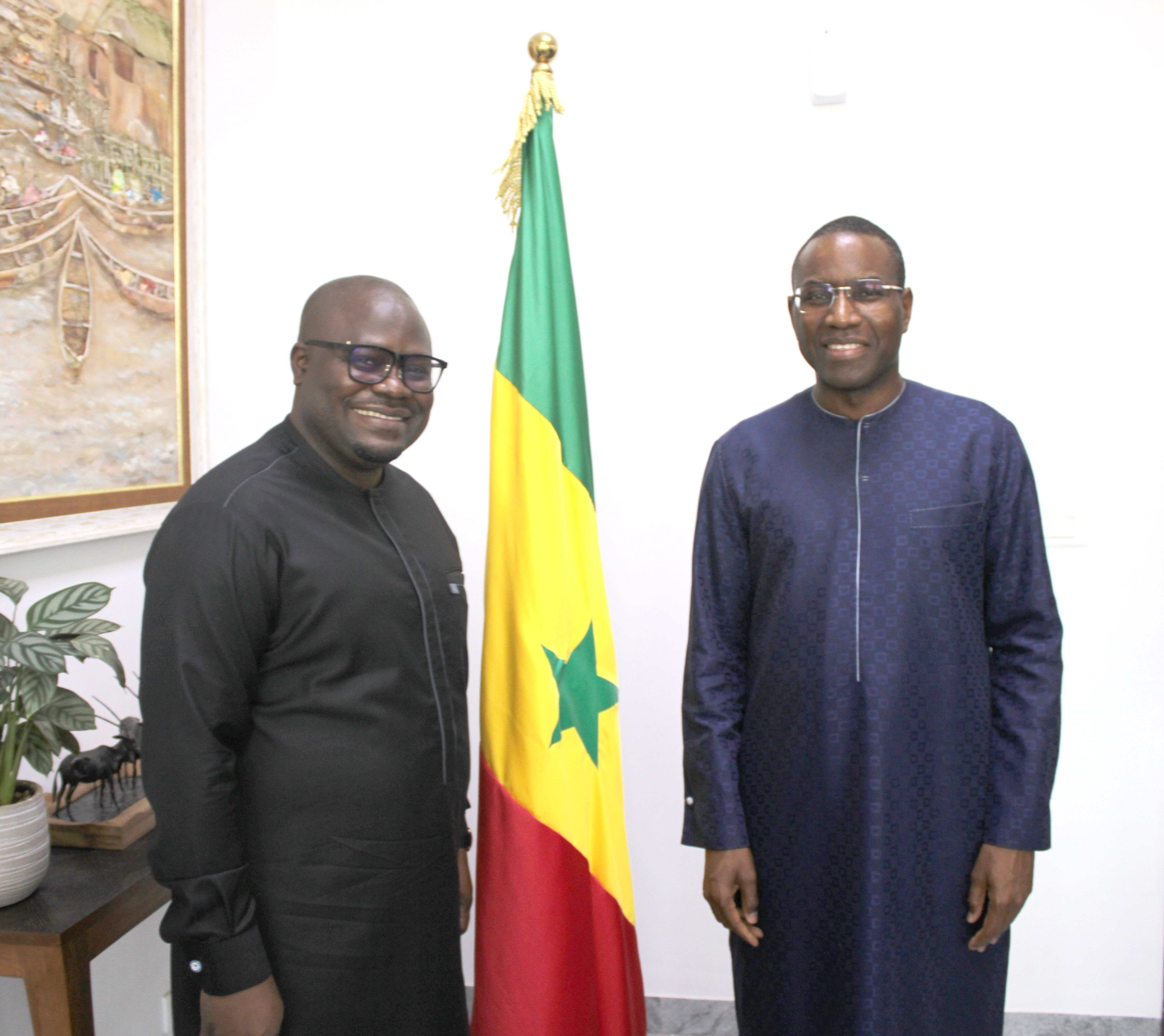 Deux hommes devant le drapeau du Sénégal
