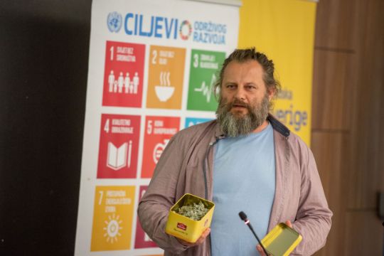 man speaking in front of SDGs