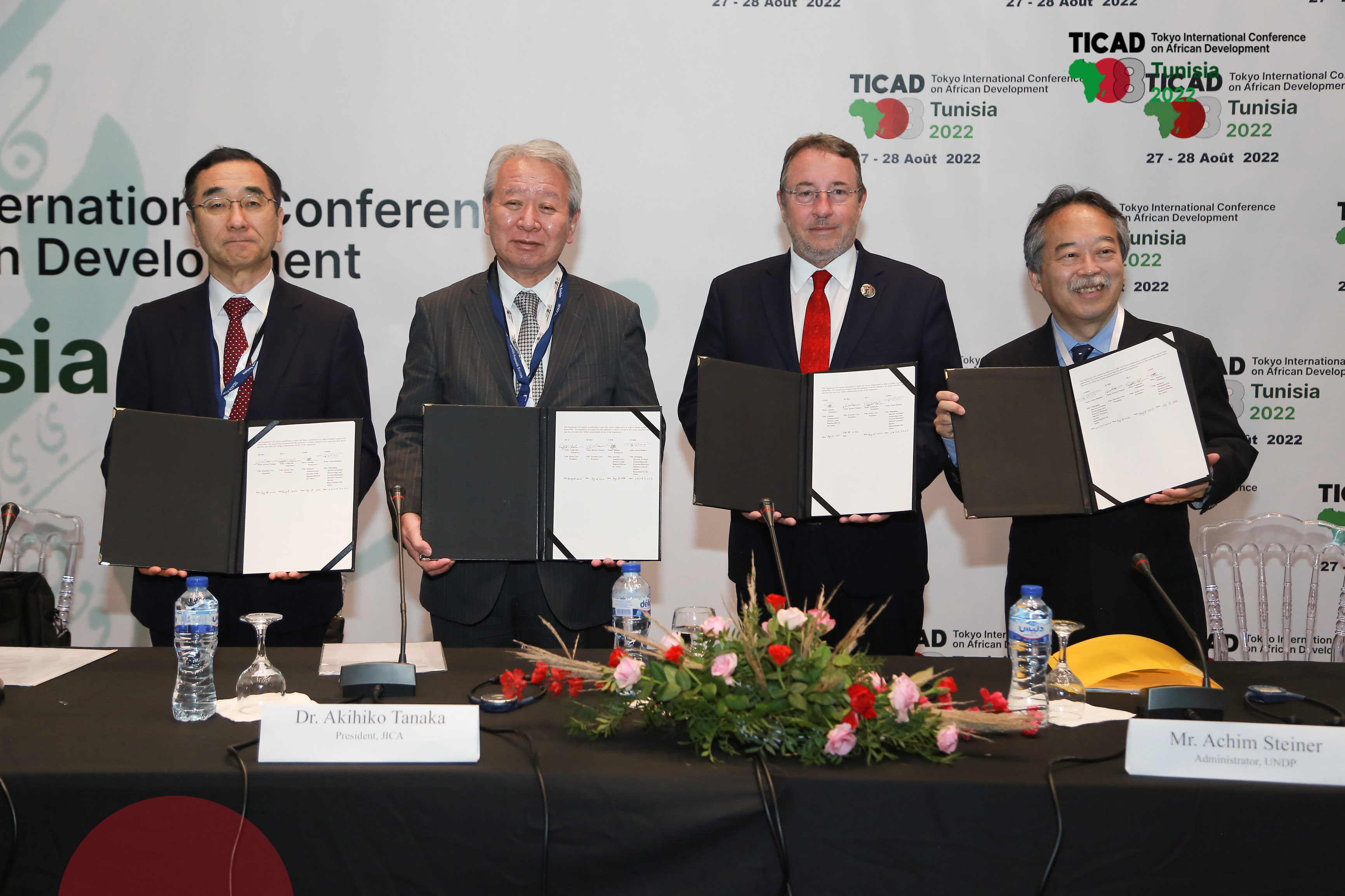 Four partner organisations holding agreement document