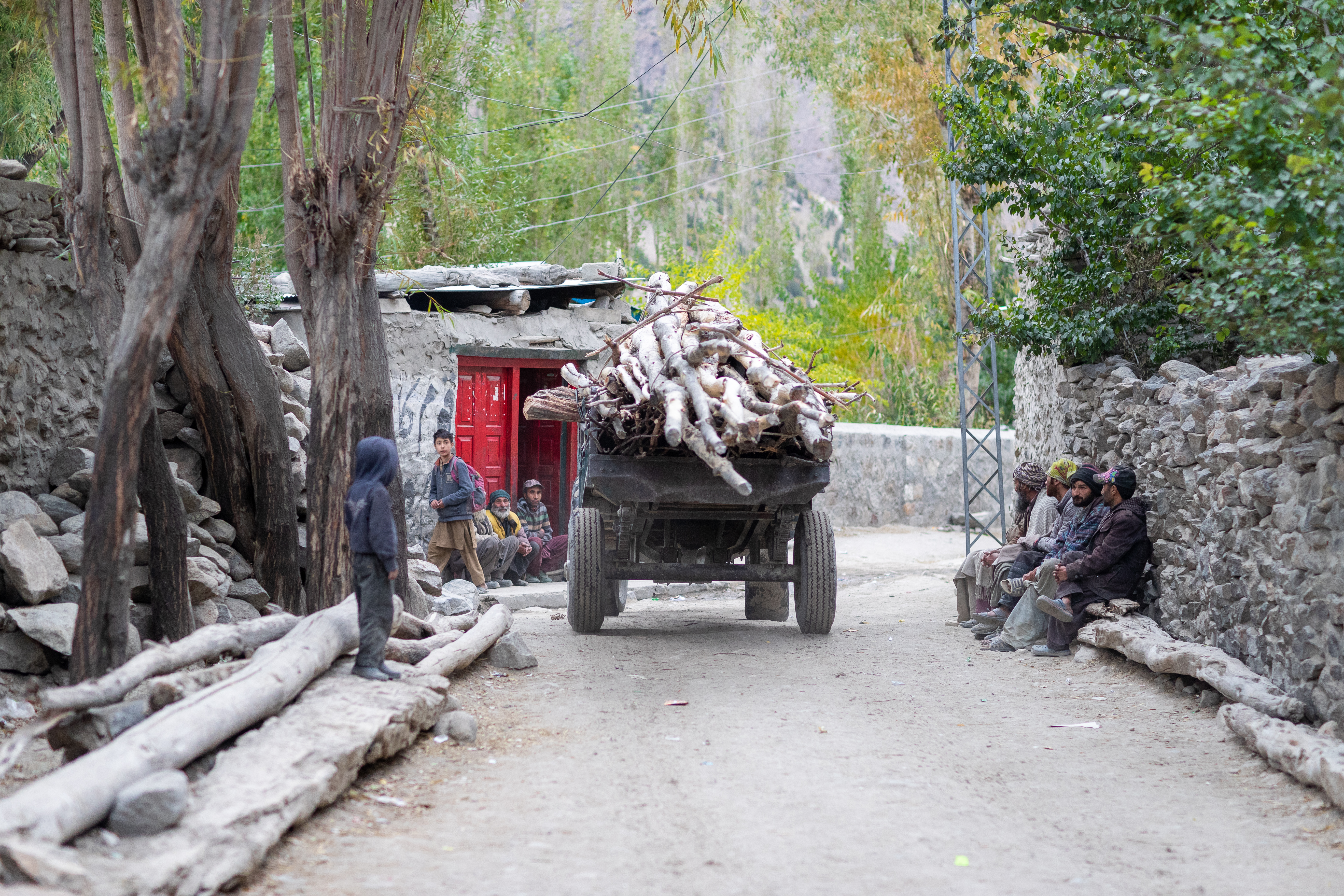 truck carrying woods with villagers standing and sitting around in Hushe Valley