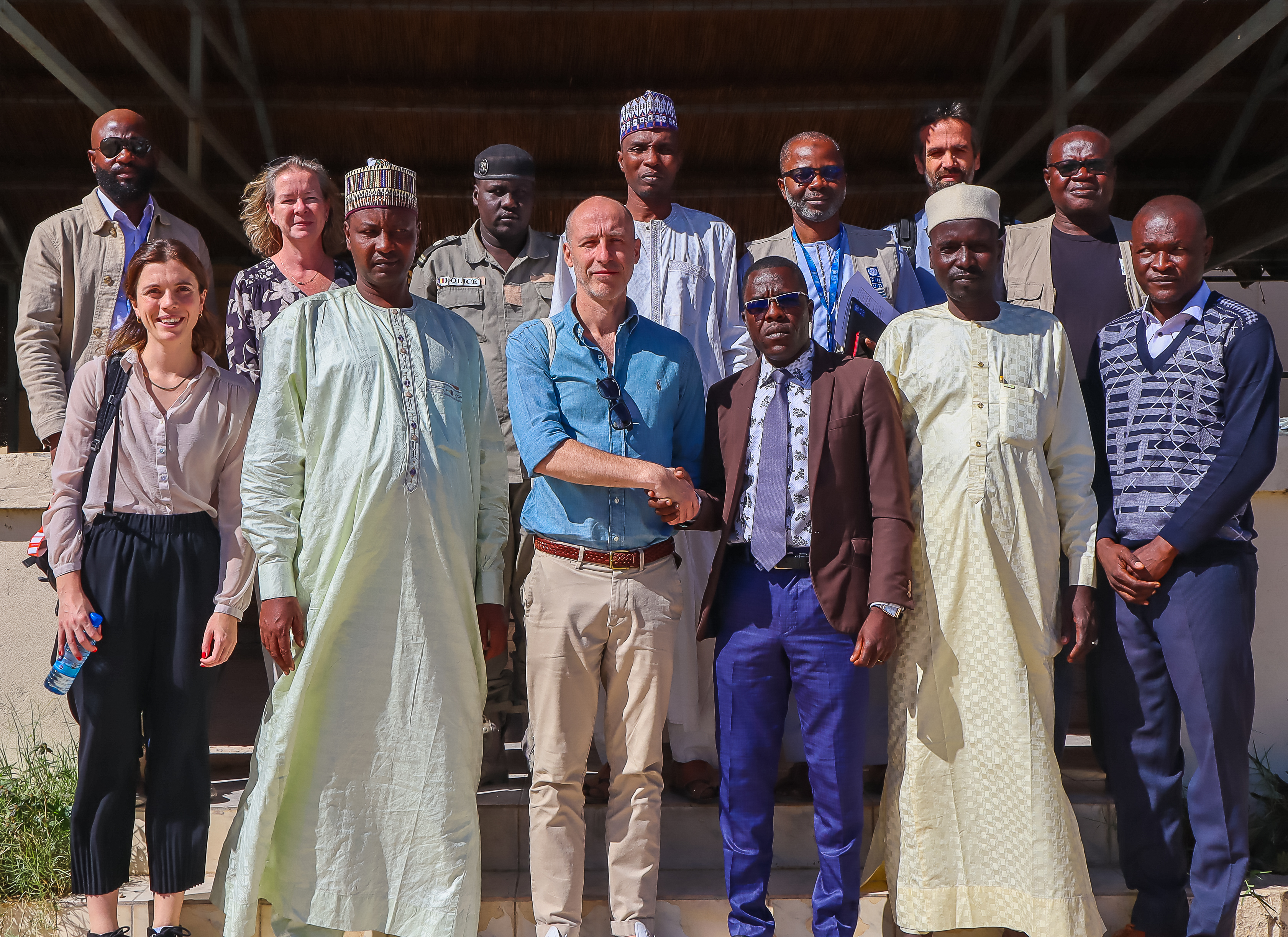 L'ambassadeur du Royaume-Uni au Tchad partage une poignée de main avec le représentant du gouverneur de la région LAC ; sur l'image figurent également des membres du personnel du PNUD et des délégués de l'ambassade du Royaume-Uni.