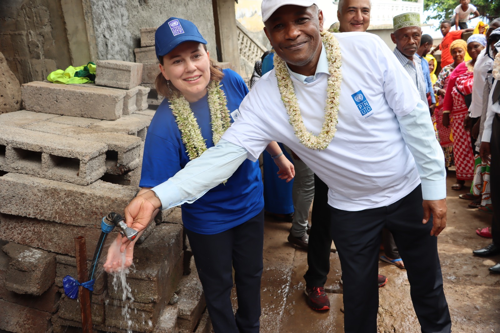 UNDP representatives turning on drinking water tap in Comoros