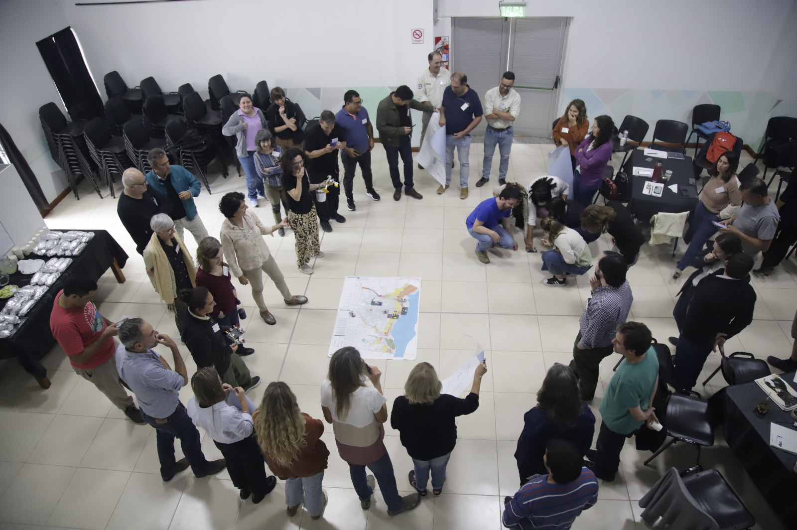 Grupo de hombres y mujeres intercambian durante curso sobre cambio climático.