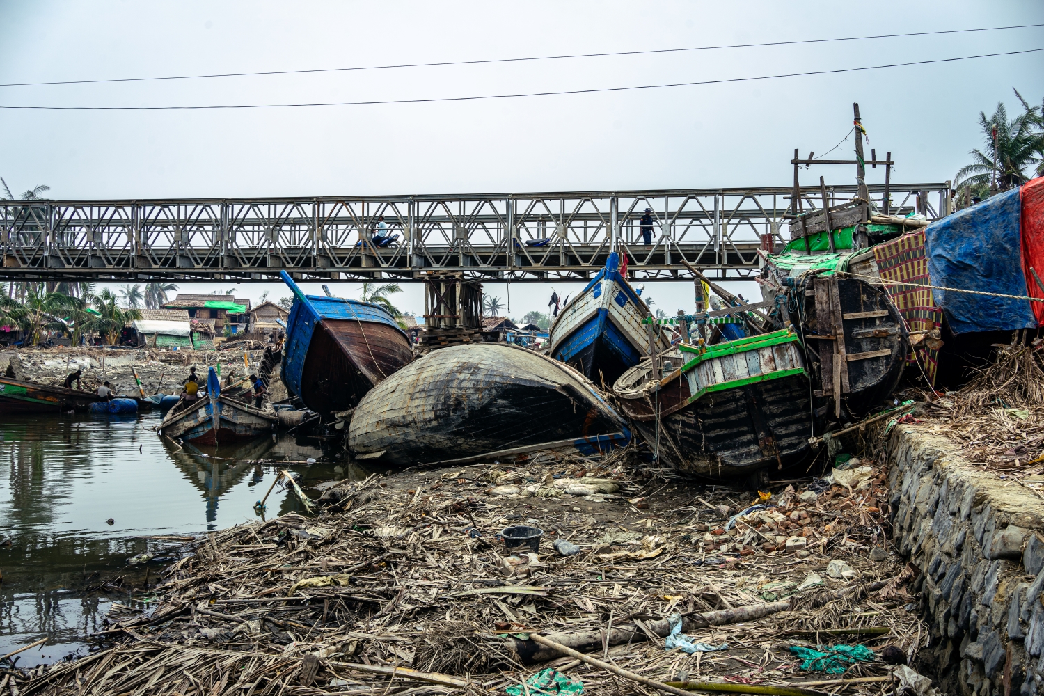 စစ်တွေမြို့ကုန်းတွင်းပိုင်းသို့ ဝင်ရောက်တိုက်ခတ်ခဲ့သော ဆိုင်ကလုန်းမိုခါကြောင့် ငါးဖမ်းလှေများ နစ်မြုပ်ပျက်စီးနေပုံ။ ဓါတ်ပုံ