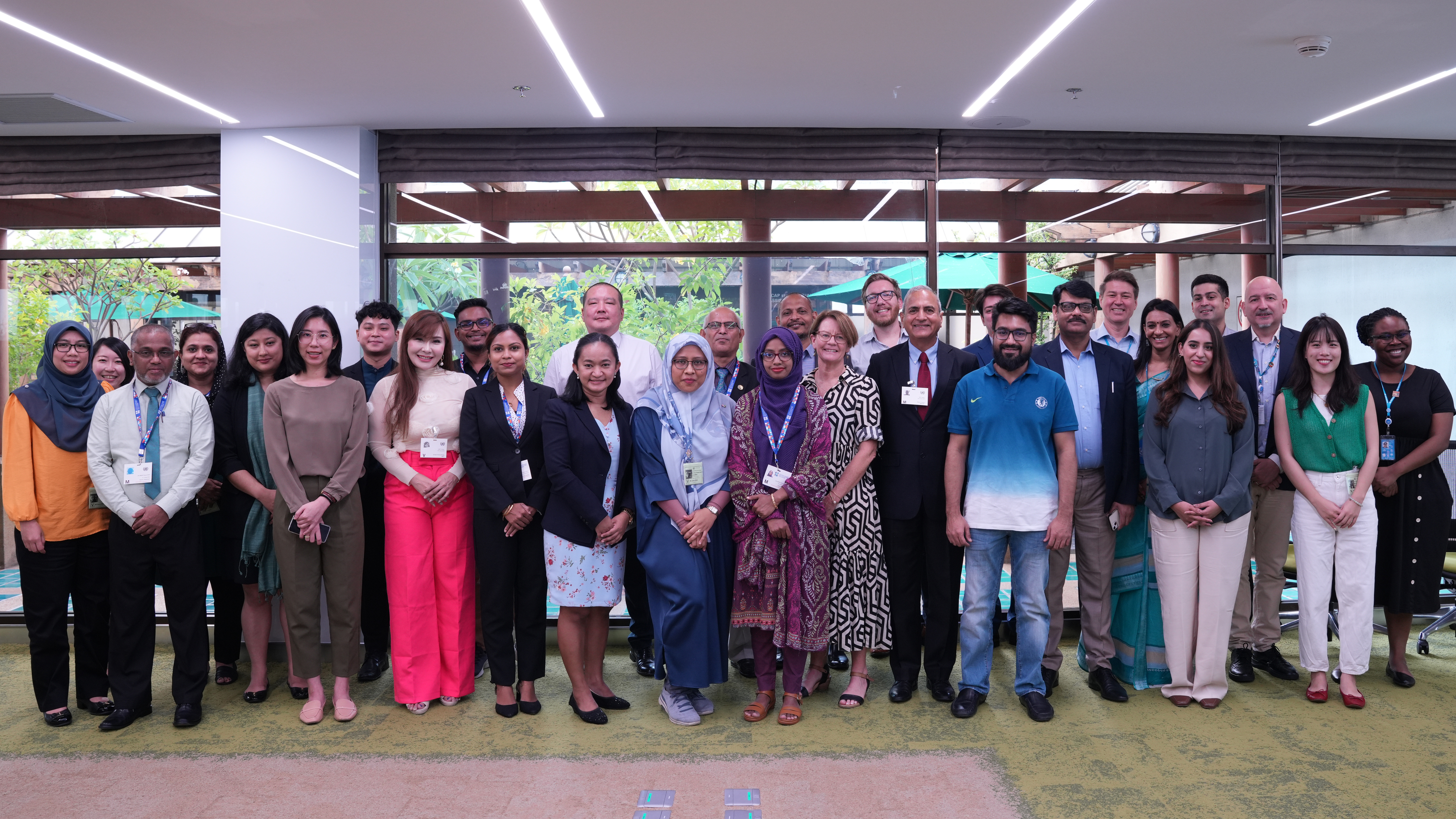 A group of representatives of national human rights institutions from across Asia stand together for group photo from training on business and human rights