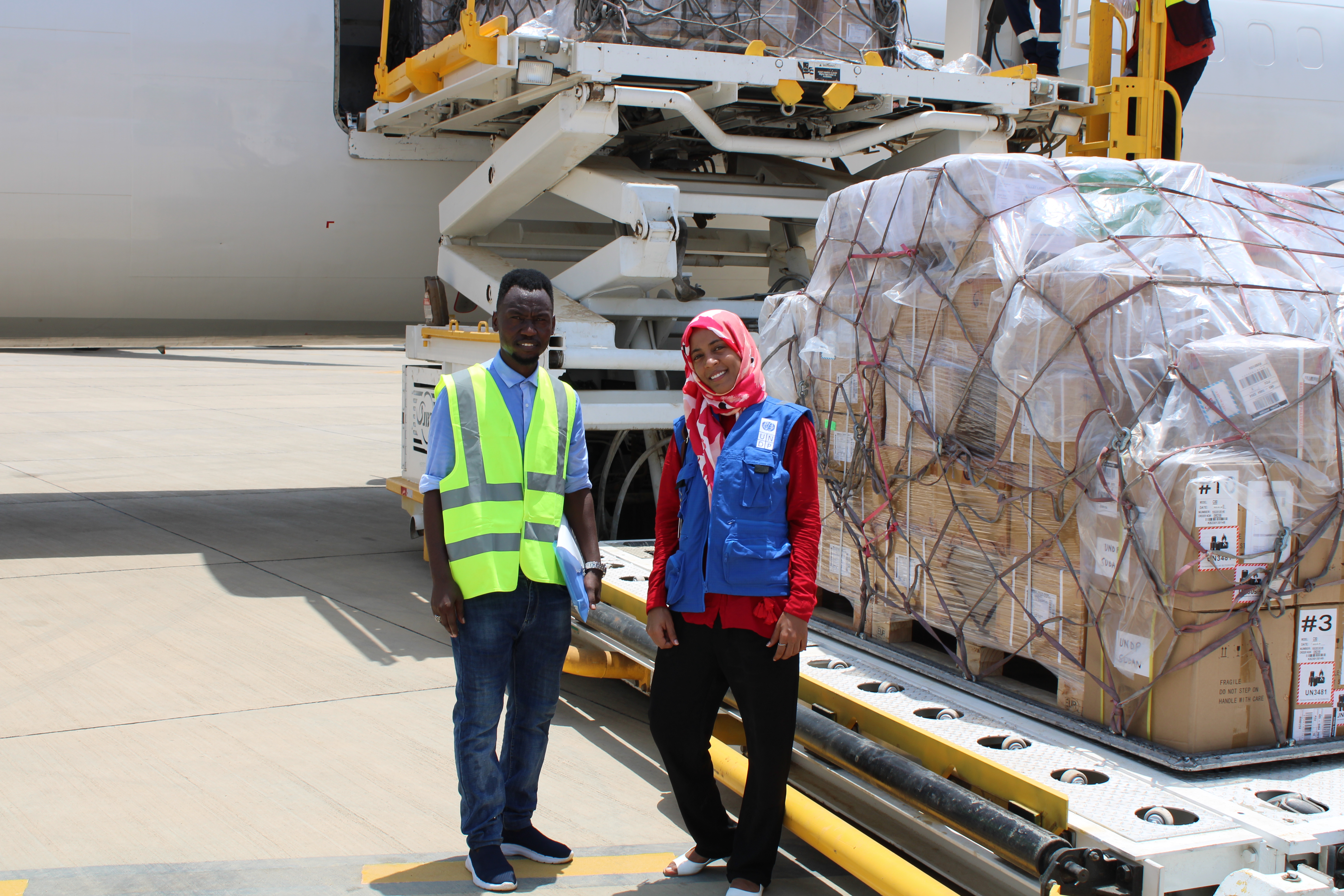 man and woman standing in front of plane cargo