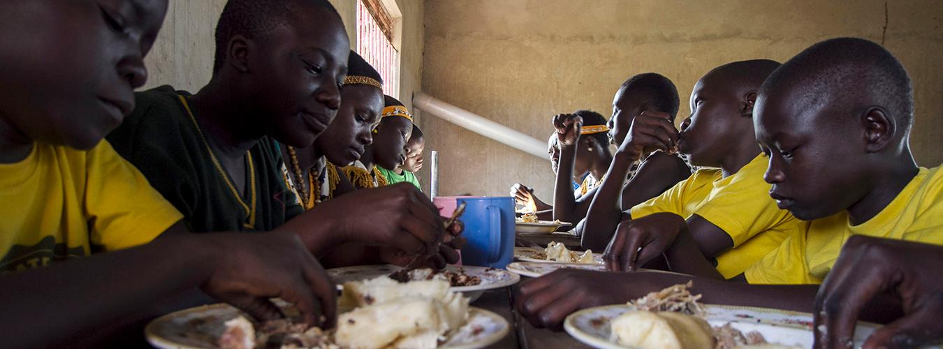  Students of the Lira integrated fish farm in Uganda, a South-South Cooperation Facility for Agriculture and Food Security, eat their lunch. Photo:©FAO/Isaac Kasamani