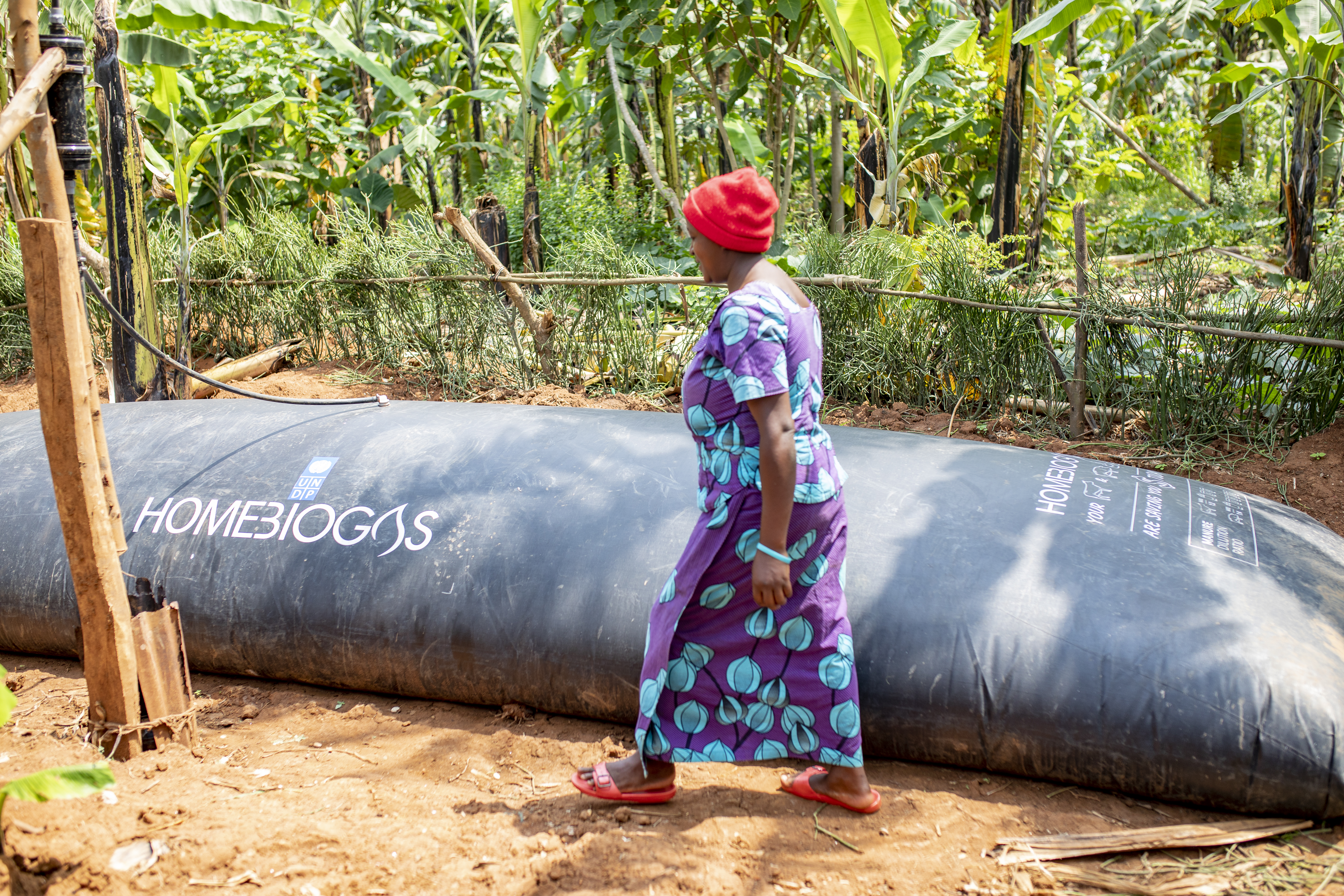 woman walking along side Biogas container