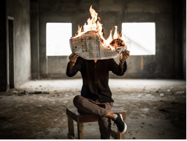 A man with his newspaper on fire.