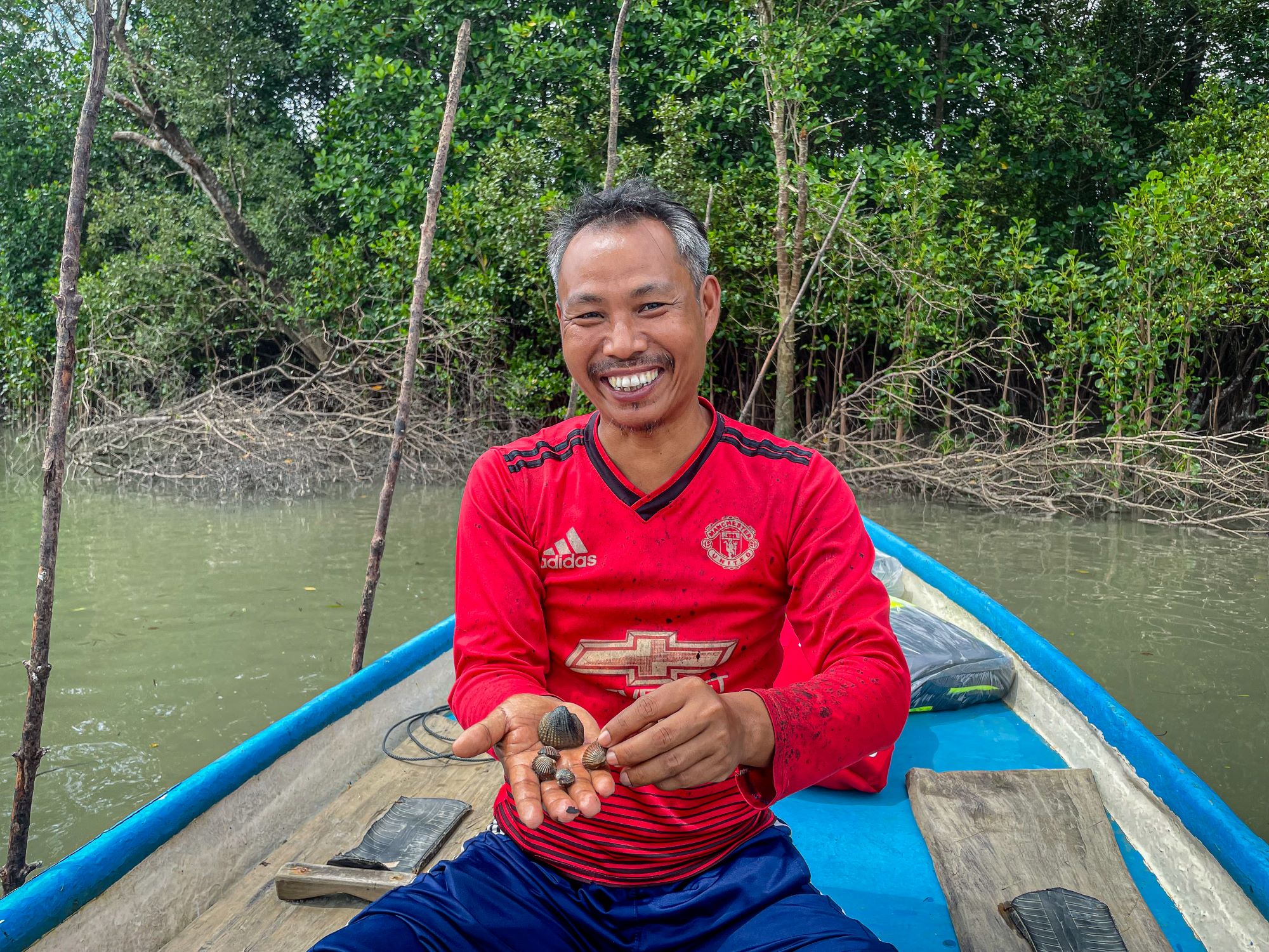 Resilience amid a crisis, U Tun Kyaw Aung displays clams farmed in a mangrove forest near his village, in the Tanintharyi Region.