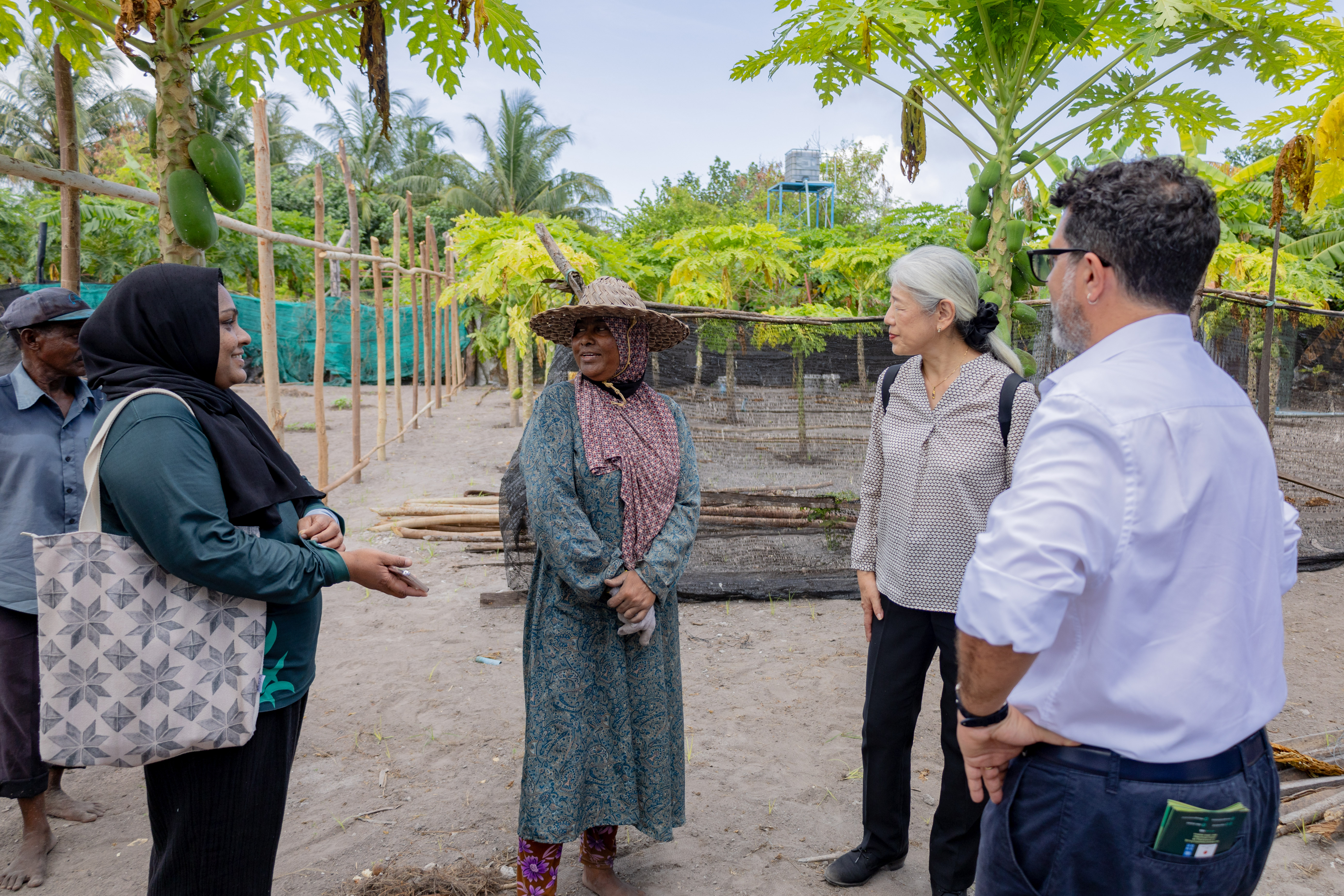 woman farmer talking to Japanese Ambassador and UNDP Res Rep with AgroNAT official