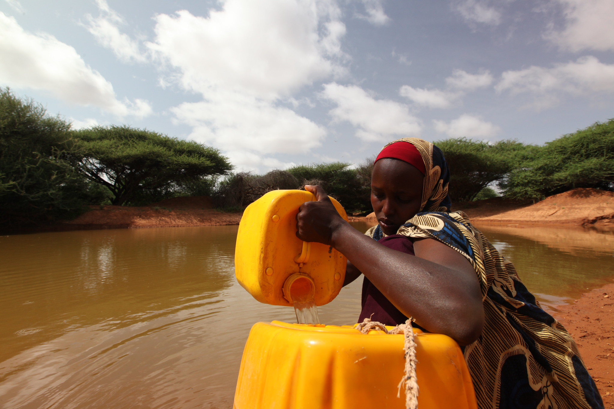 Somali woman pouring water into container