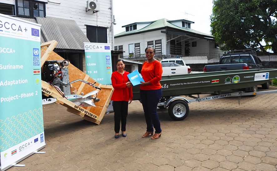 Mrs. Haidy Malone, GCCA+ Project Manager, hands over the 15-foot Pan boat and an outboard motor to Ms. Claudine Sakimin, Coordinator Nature Conservation Division