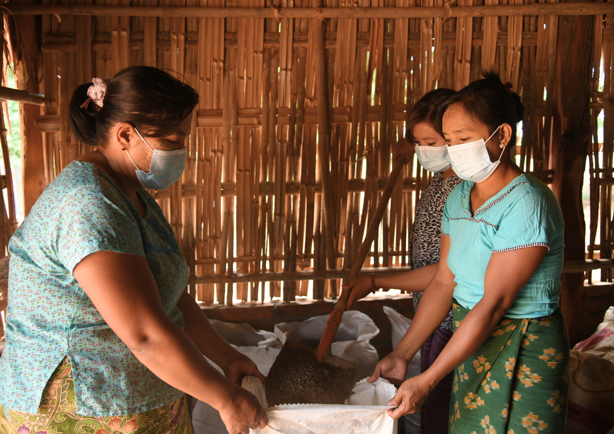 Ma Mu Mu Htay and her business partners work together in the warehouse, preparing the first batch of their natural fertilizer for the market