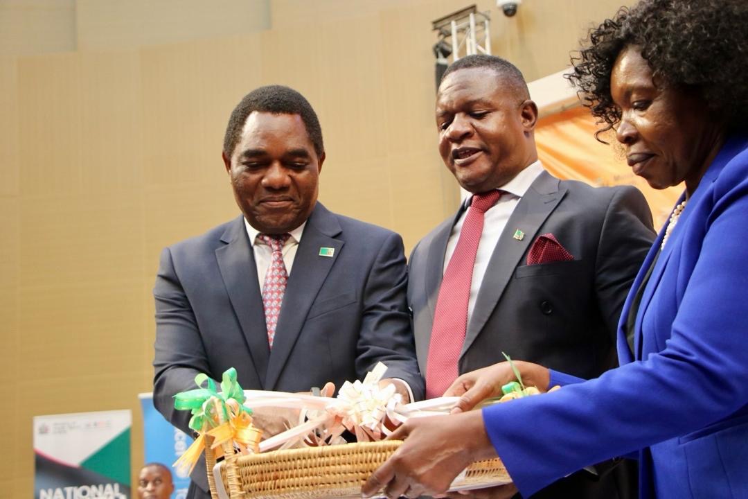 An image of President Hakainde Hichilema, Minister of Youth Sport and Arts Elvis Nkandu and United Nations Zambia Resident Coordinator Beatrice Mutali holding a basket with the 2024 National Youth Policy