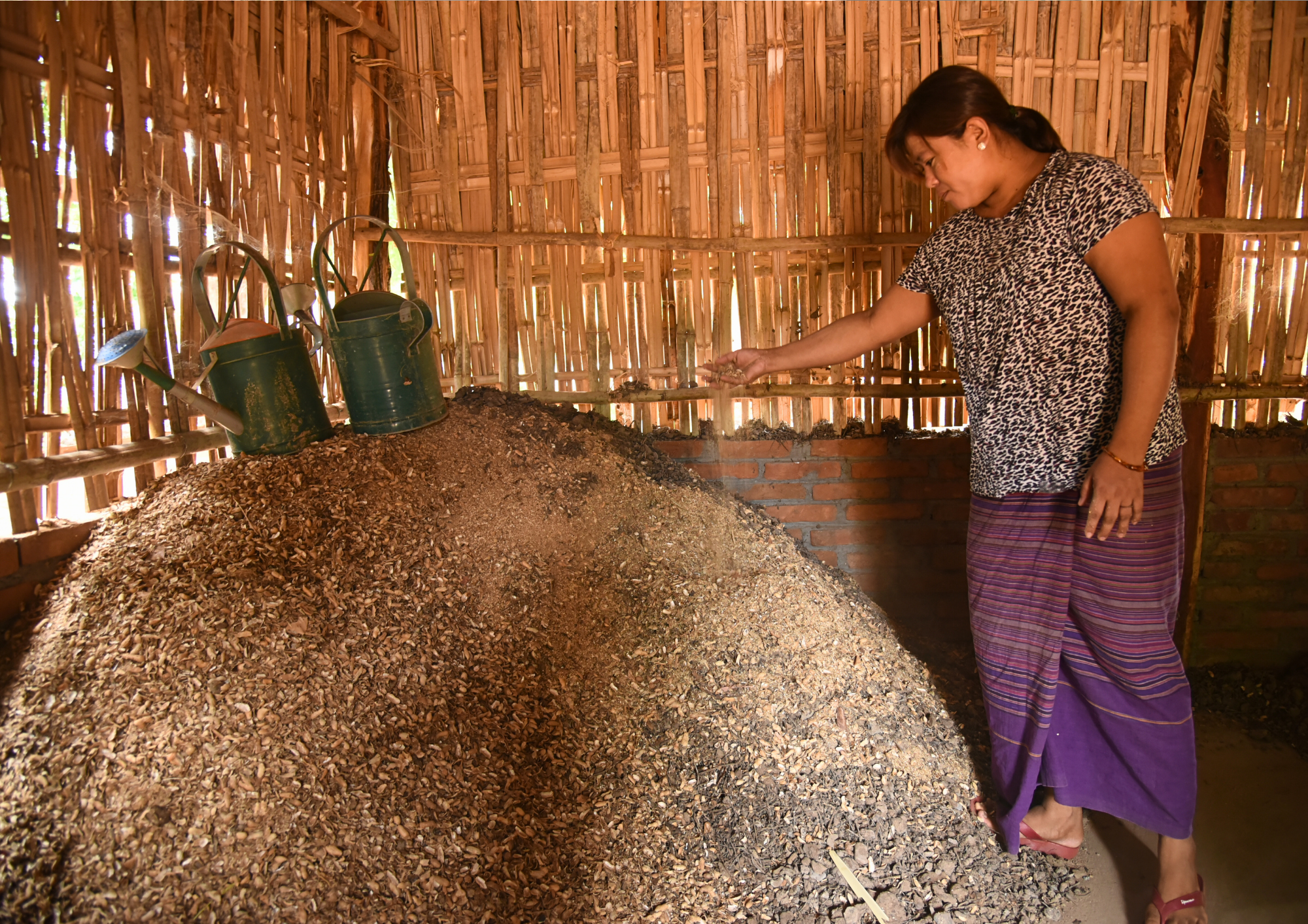 Precision in practice: Ma Mu Mu Htay meticulously inspects her initial natural fertilizer mixer, verifying the seamless blending of raw materials