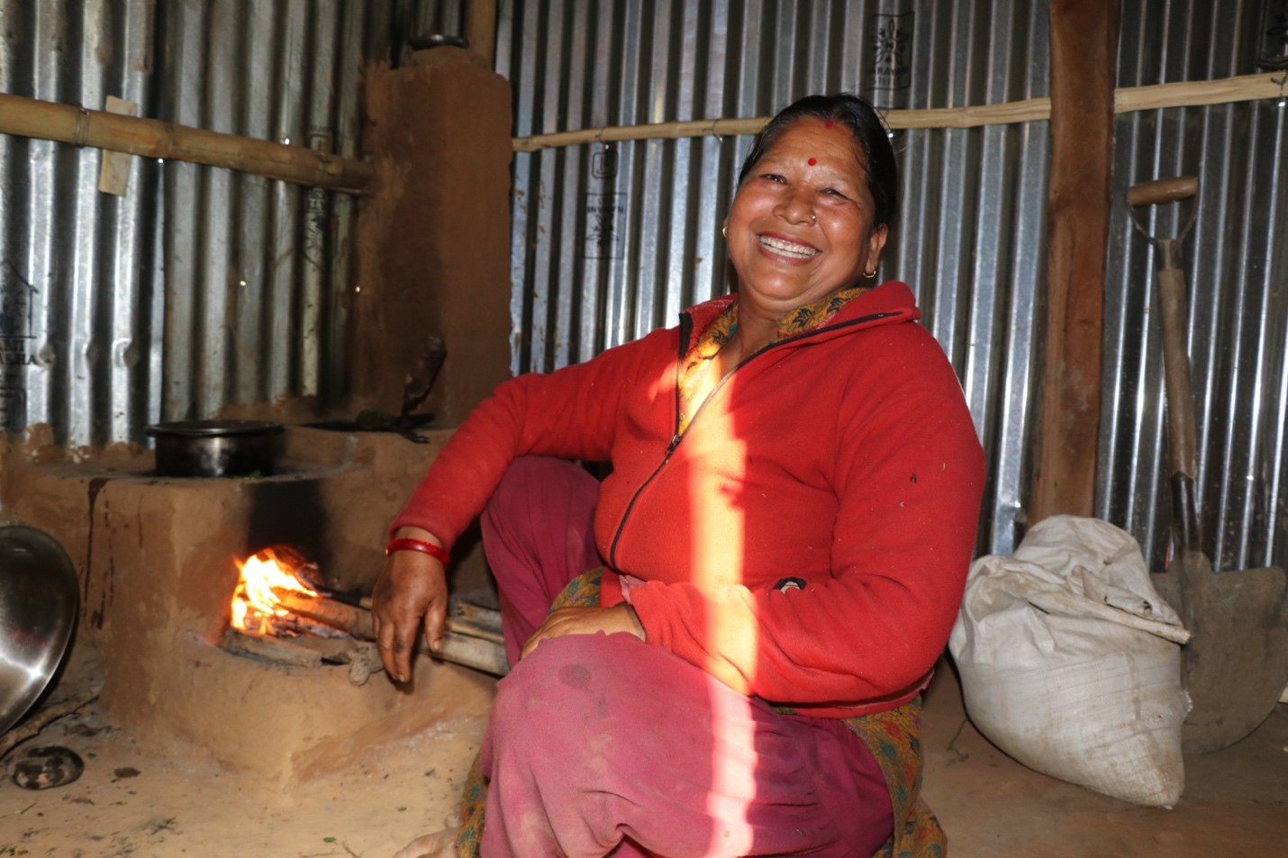 A woman posing with a big smile while cooking food