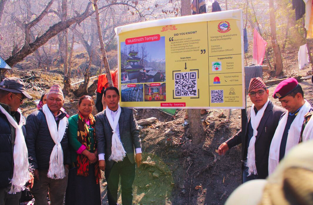 people posing in front of a QR board in Muktinath temple