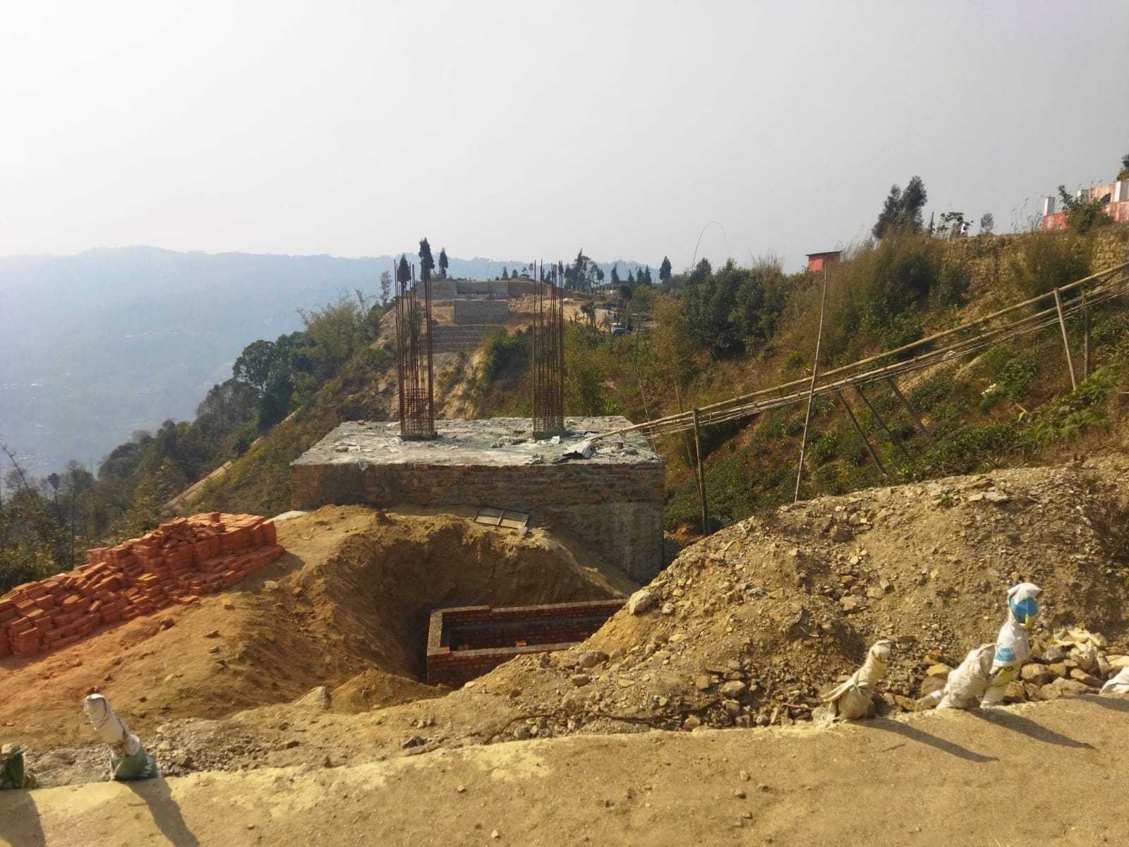 a picture of an Under-construction suspension glass bridge in Ilam connecting 2 hills