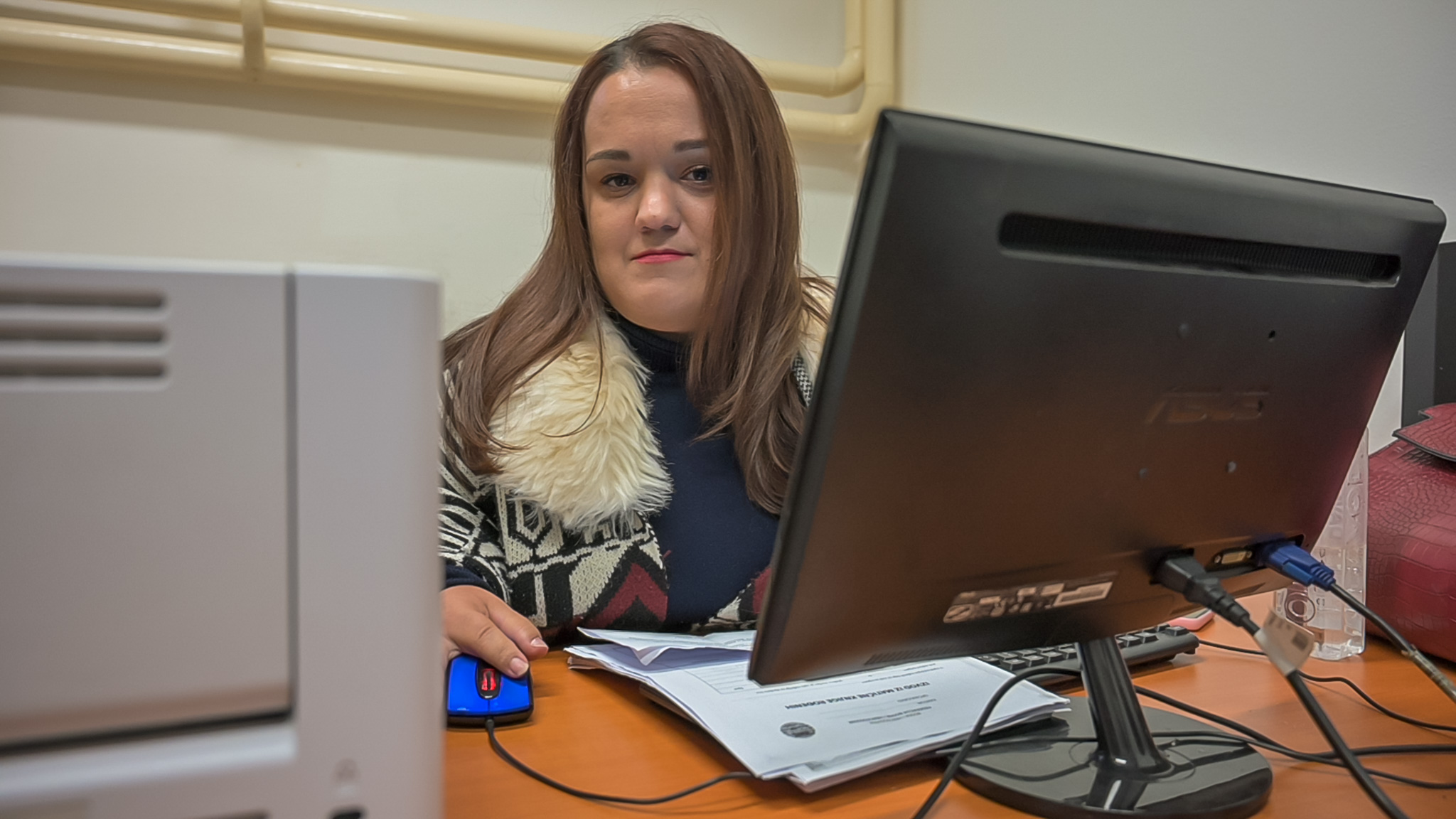 a person sitting at a desk in front of a laptop computer