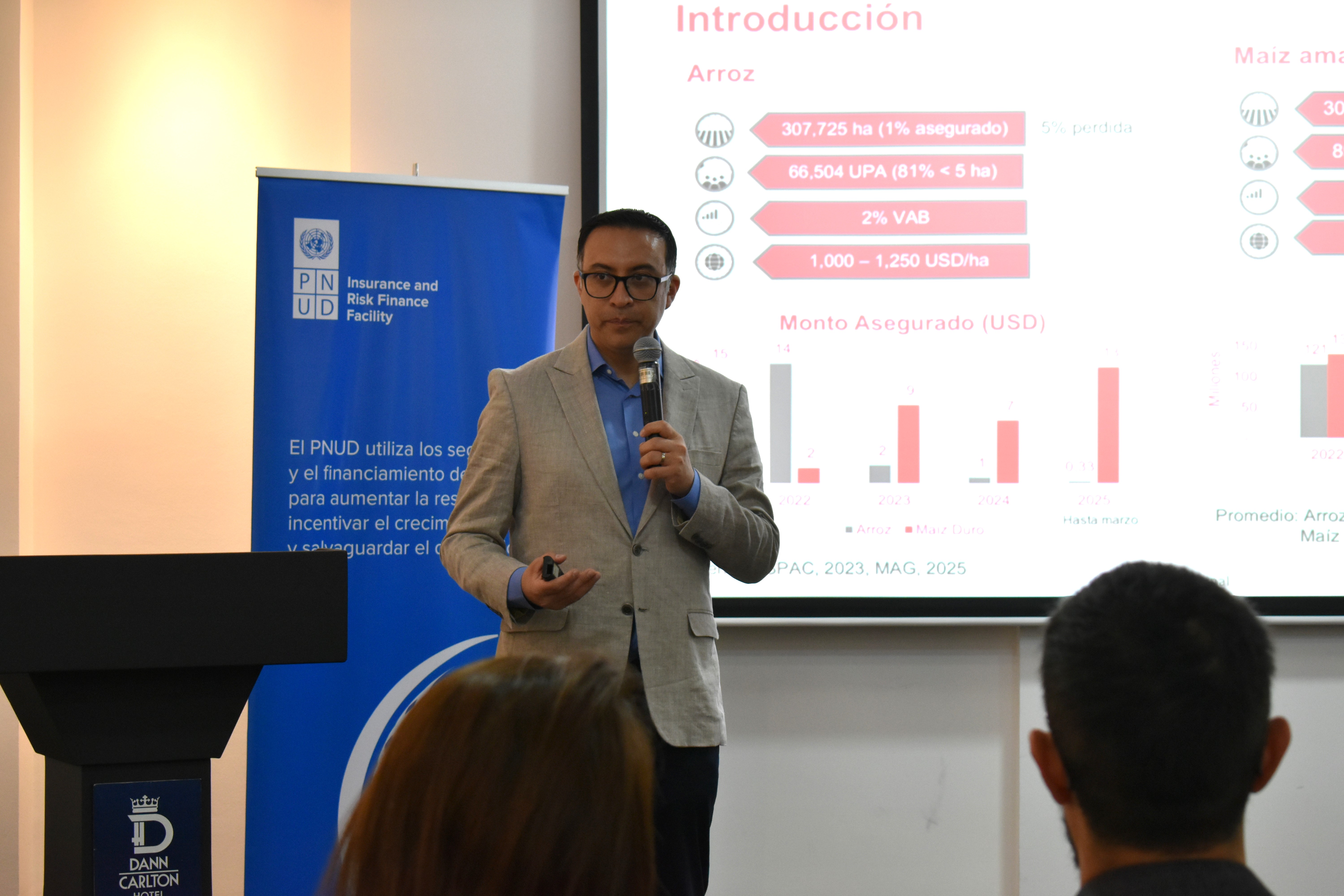 A man in a suit presents data on a screen, standing at a podium.