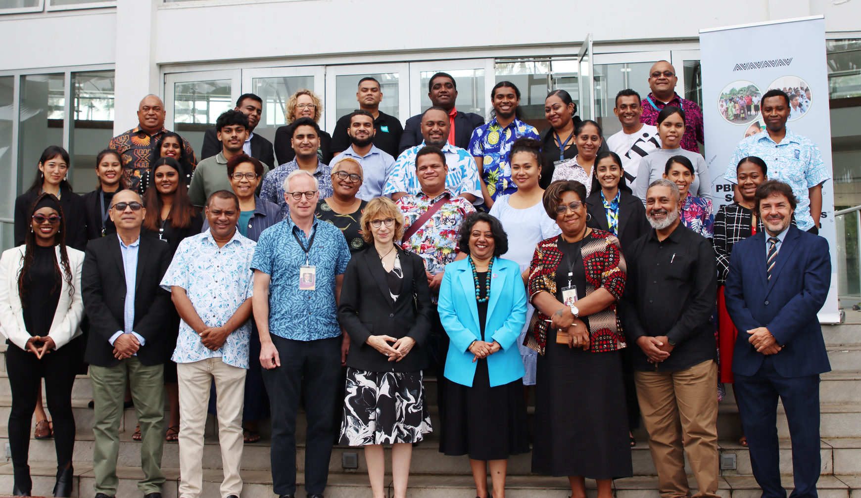 Group photo of diverse attendees smiling at a conference venue.