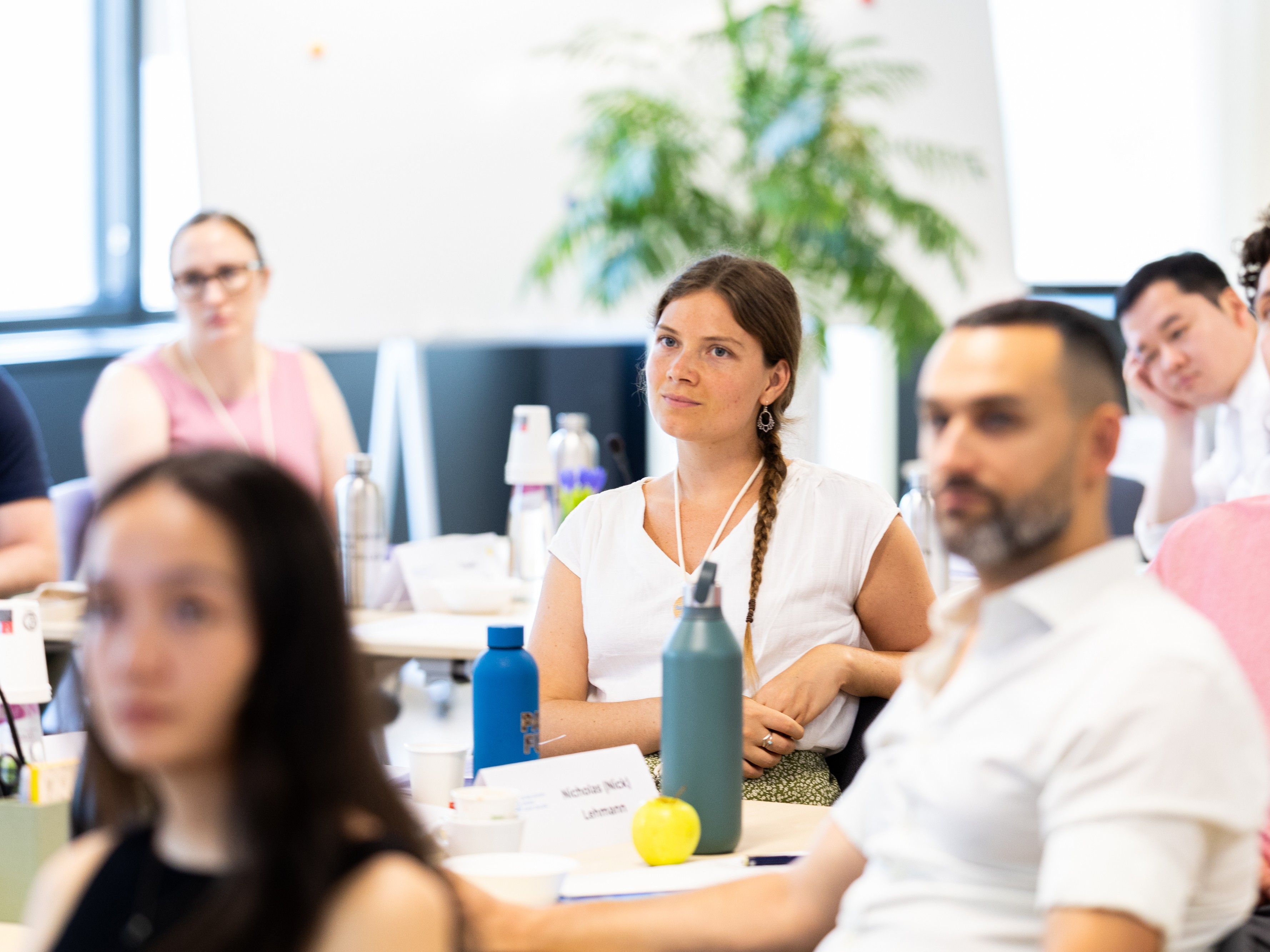 Participants attentively listening in a bright, modern conference room.