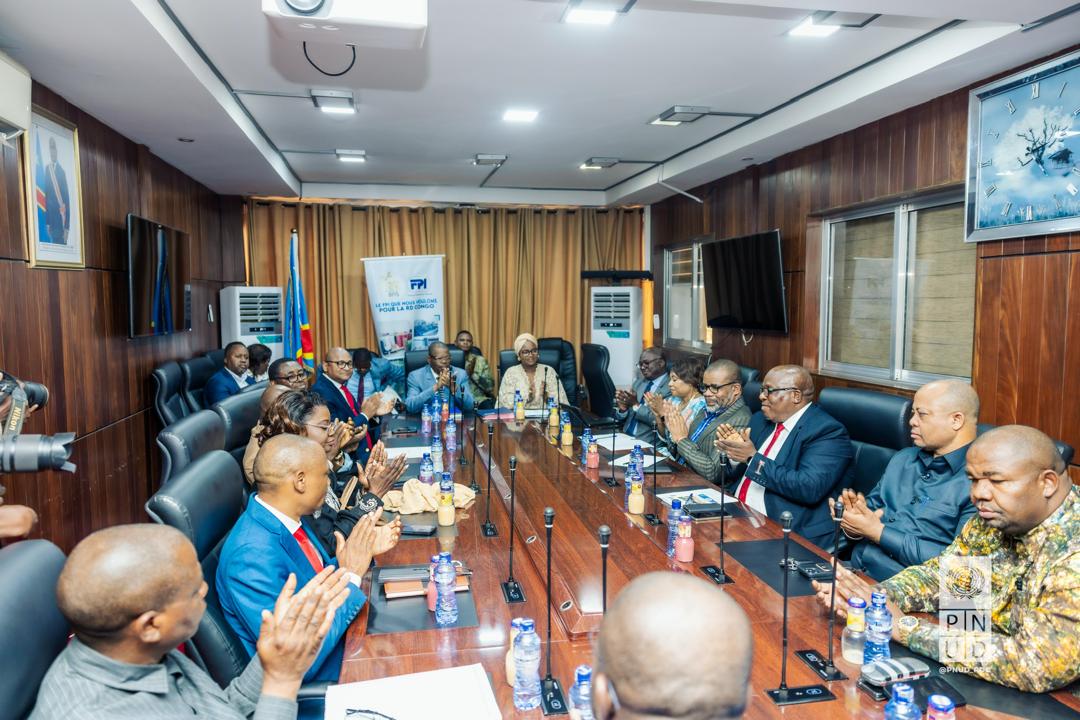 A group of people seated around a conference table in a meeting room.