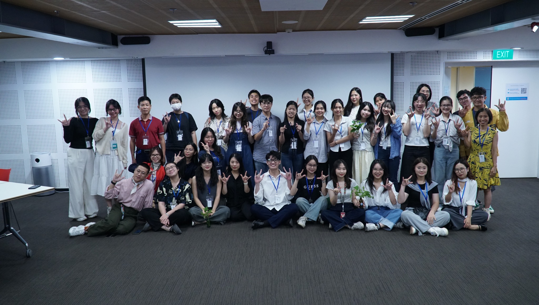 Group photo of a large team, smiling and posing together in a modern office setting.