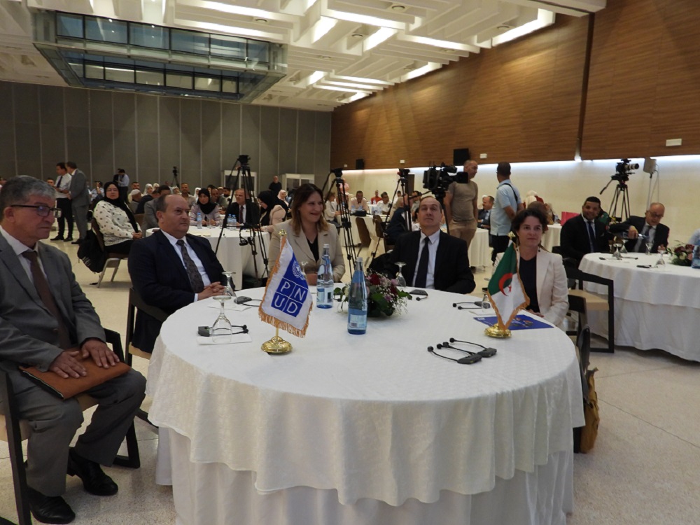 A group of people seated at tables in a conference setting, engaged in conversation.