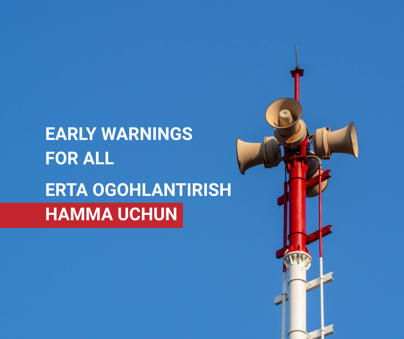 A tower with multiple loudspeakers against a clear blue sky.