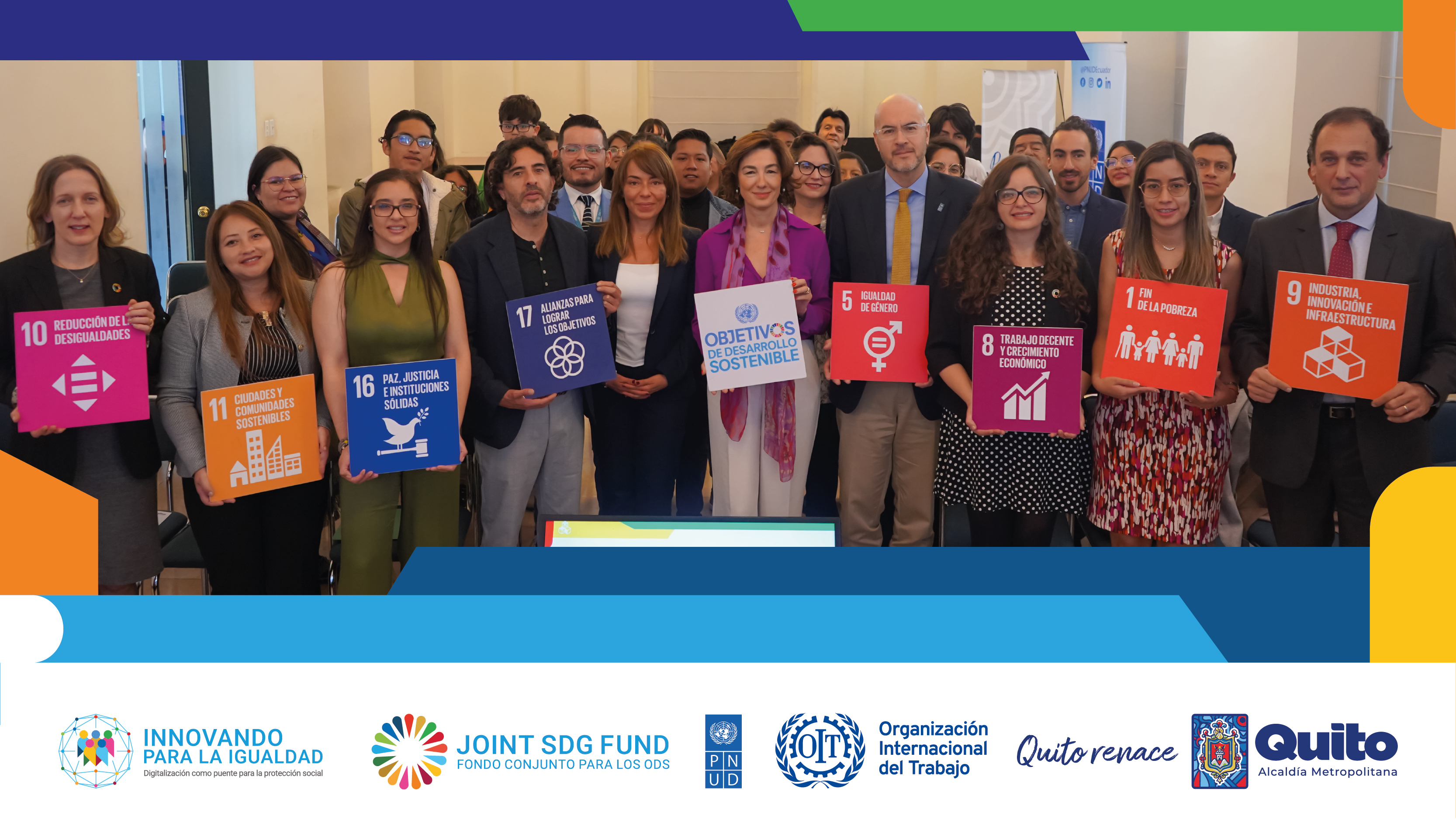 Group photo of diverse professionals holding colorful signs, smiling, in a bright indoor setting.