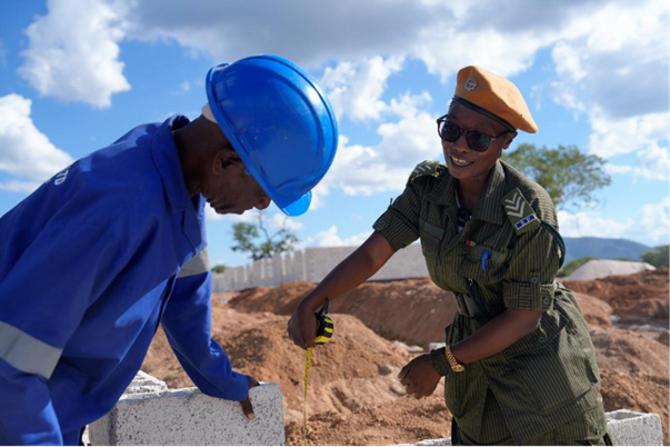 Two people holding bricks for building.