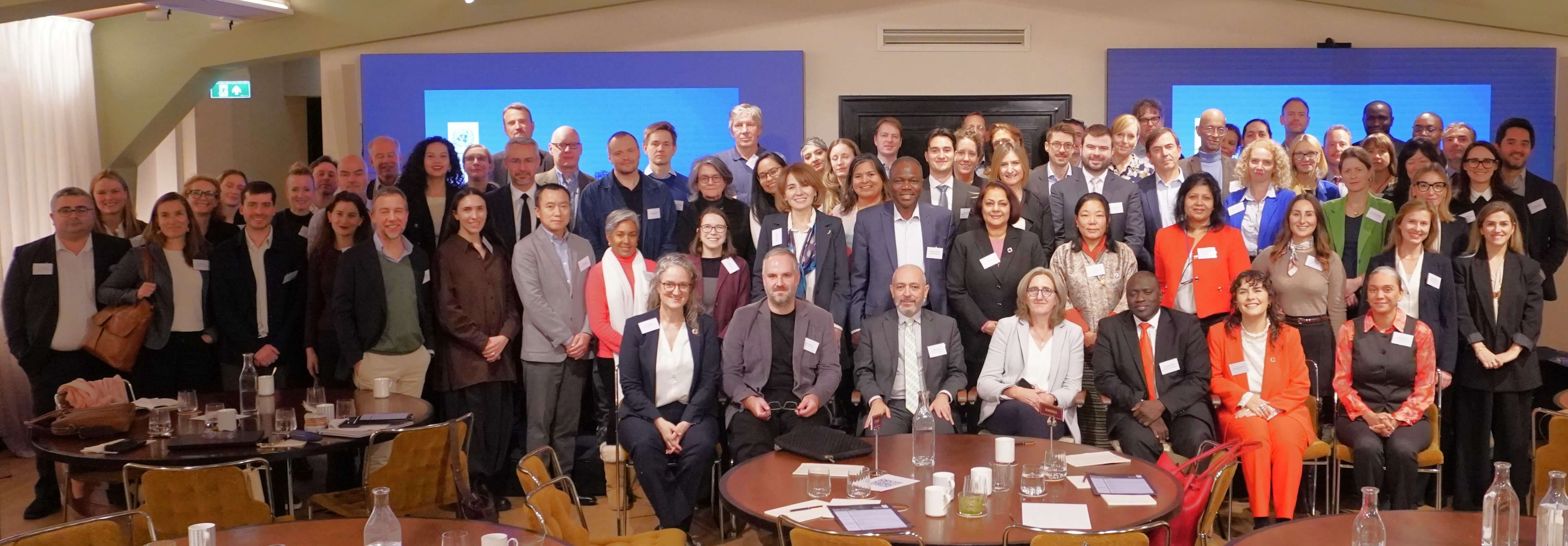 Professional group photo at a conference, with a blue banner backdrop.