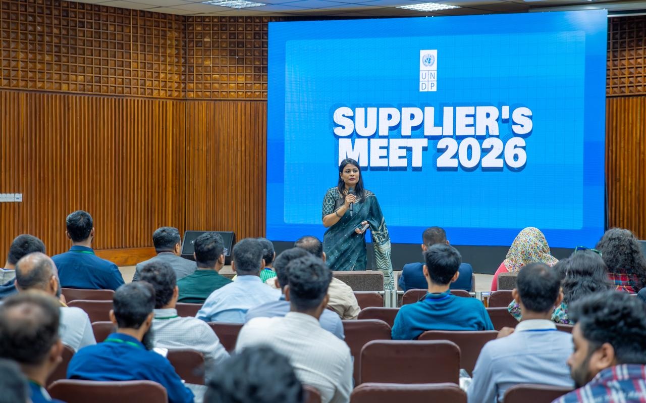 Audience watches a presenter on stage as a blue backdrop shows Supplier's Meet 2026.
