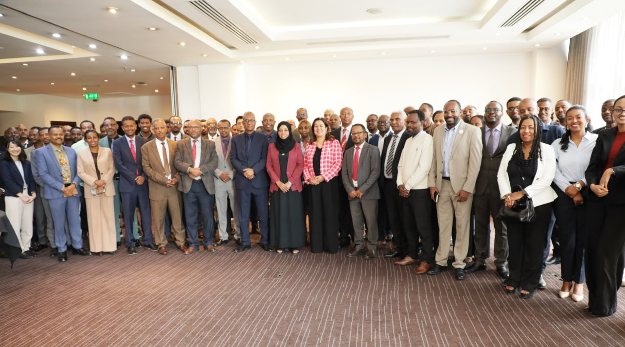 Group of professionals in business attire posing for a photo in a conference room.
