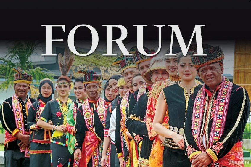 Group of people in colorful traditional costumes posing under a FORUM banner.