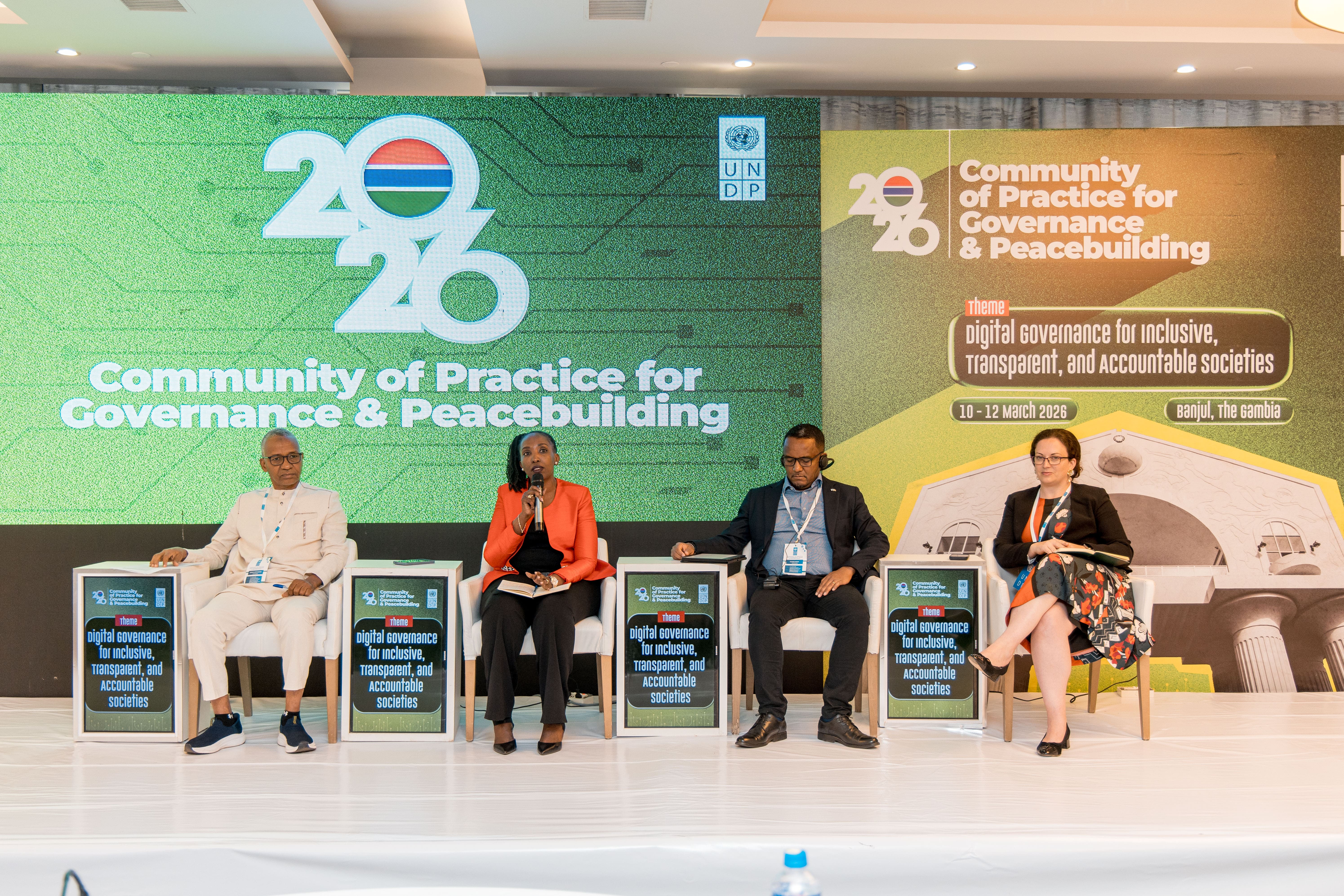 Photo: Five panelists seated on a stage with a green backdrop and a 20-year logo.