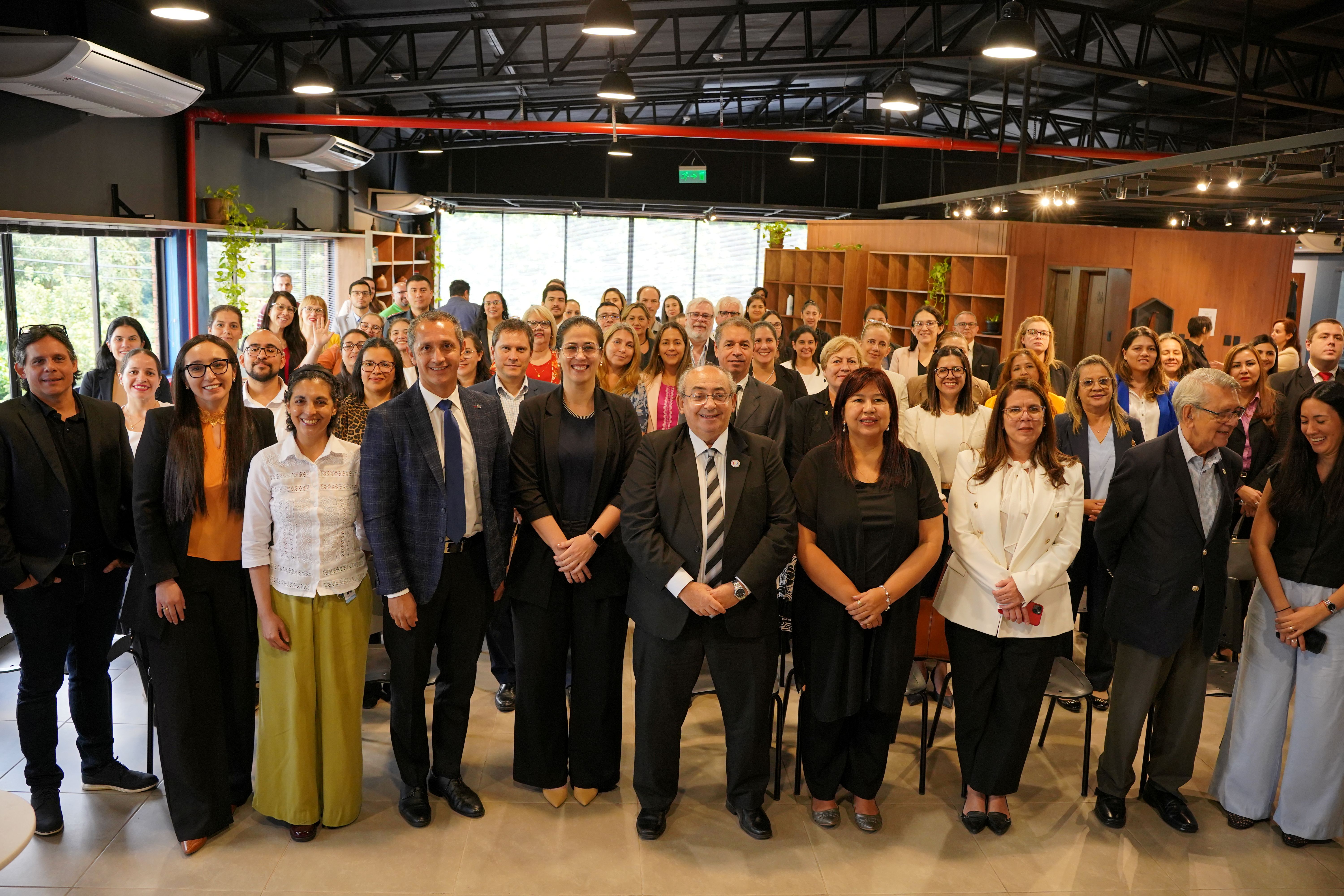 Large group of professionals posing for a group photo at an indoor event.